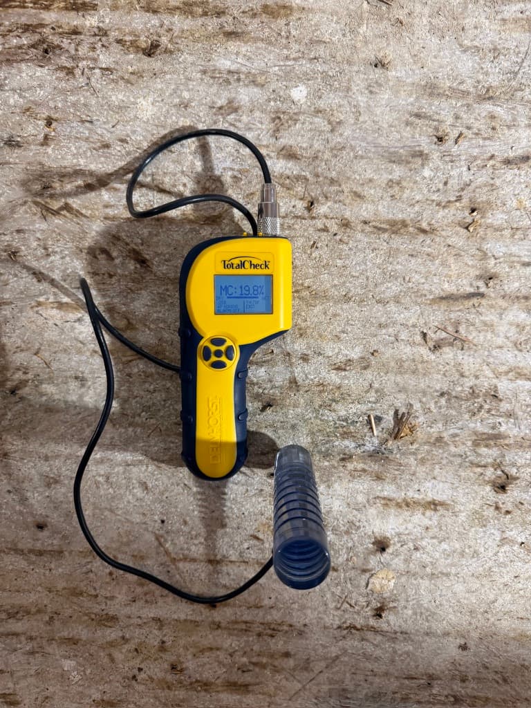 Delmhorst Total Check pin meter reading 19.8 percent on a wet subfloor