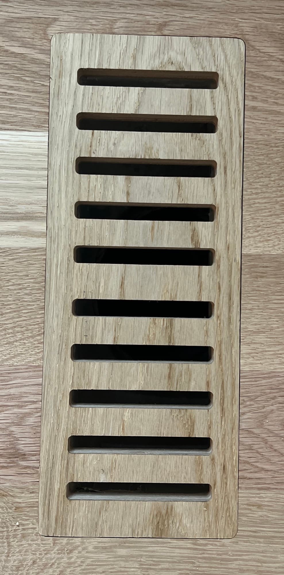 Custom flush mount white oak floor vent installed and stained to match hardwood floor Clayton NC