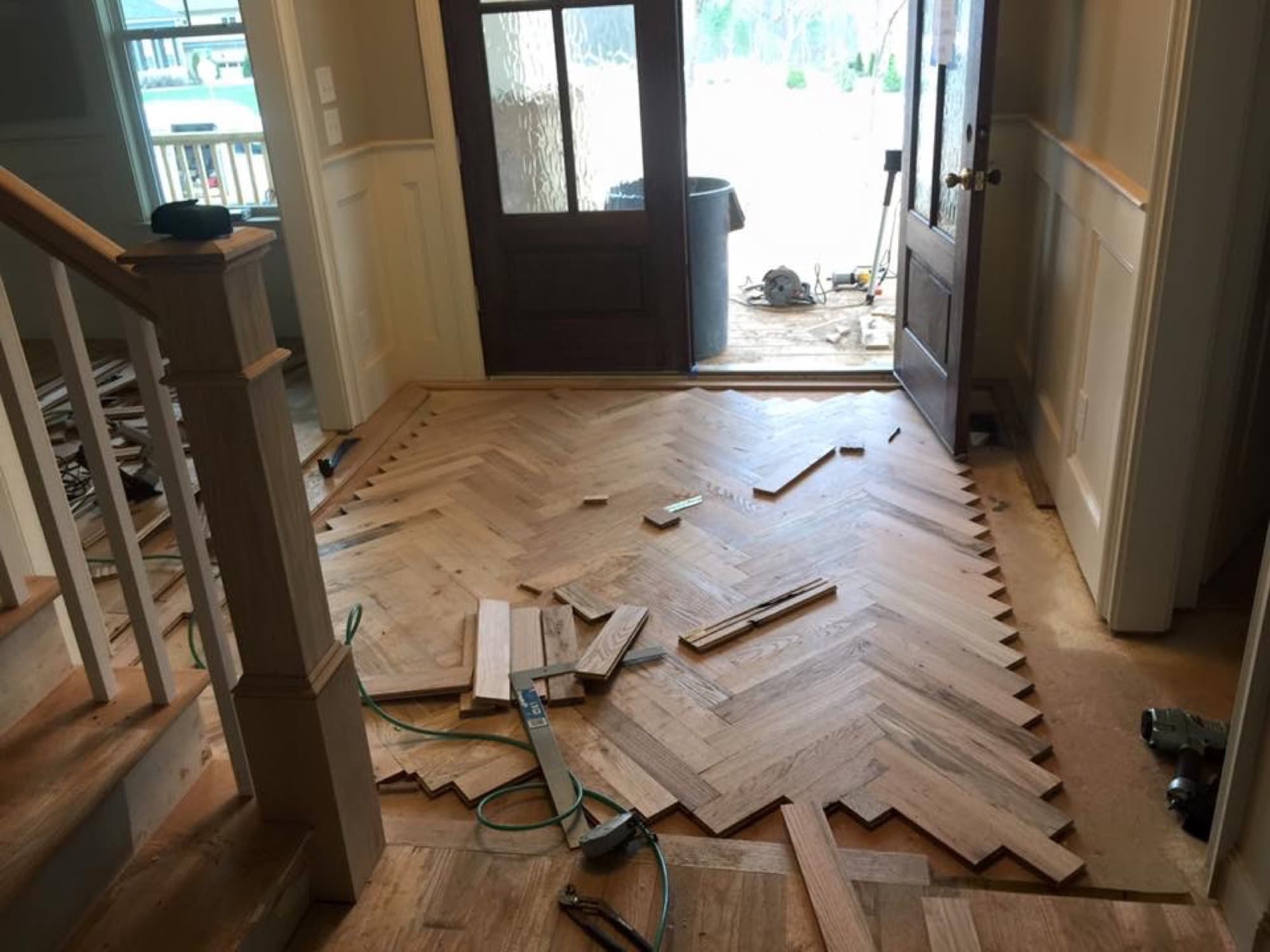 Herringbone hardwood floor installation in progress in foyer in Garner NC by 12th And Oak Floor Co.