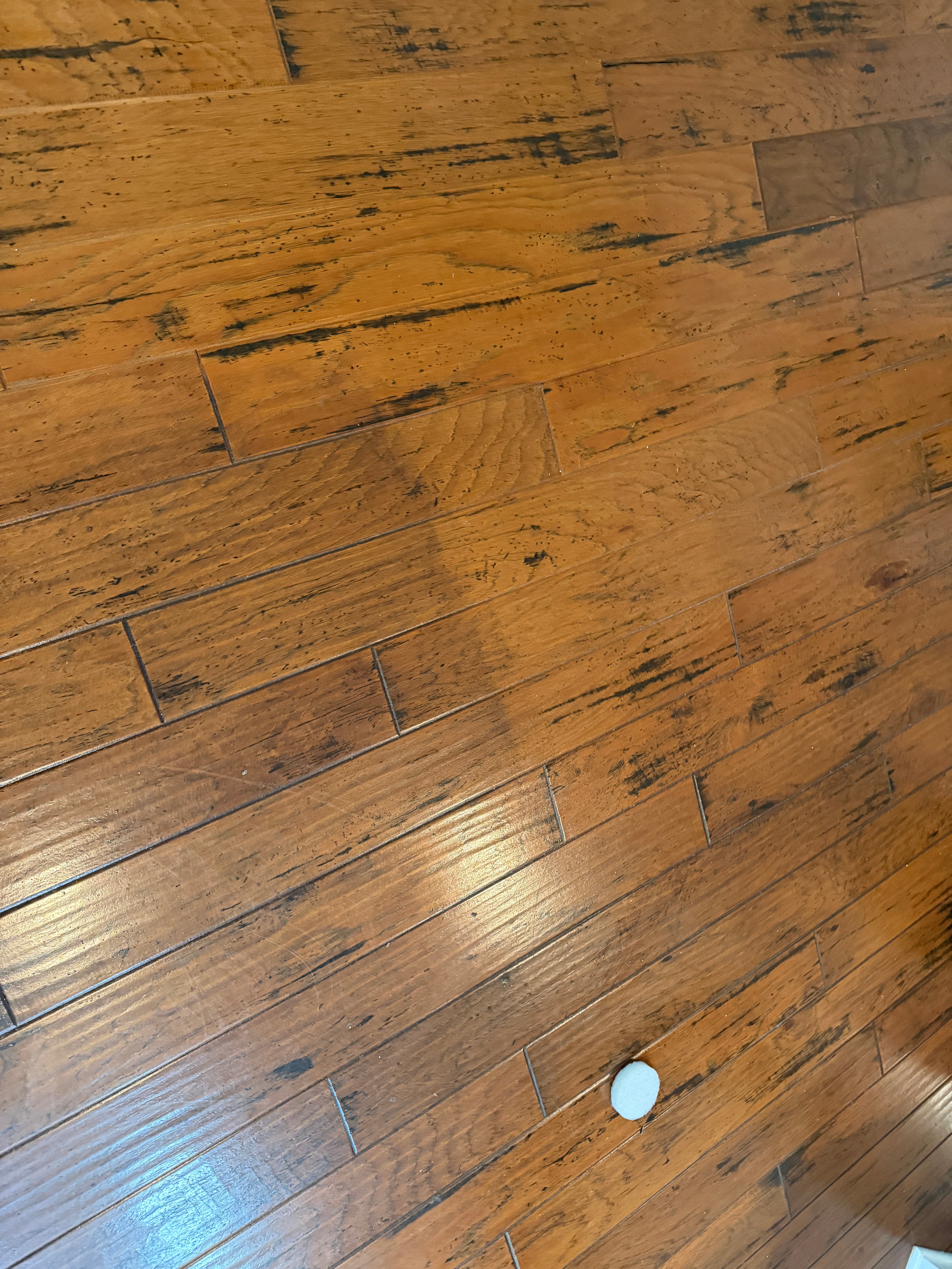 A dulled hickory surface carrying years of polish and grime, photographed before deep cleaning on a Holly Springs, NC project