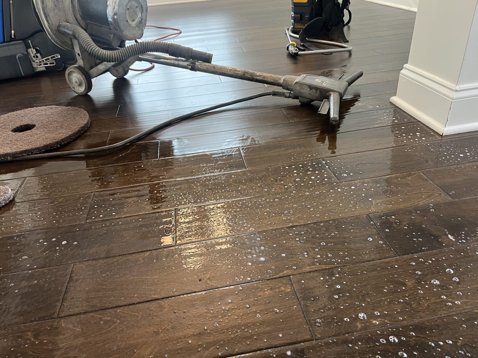 Dissolved polish being pulled off a hand-scraped floor after the buffer pass during polish removal in Fuquay-Varina NC
