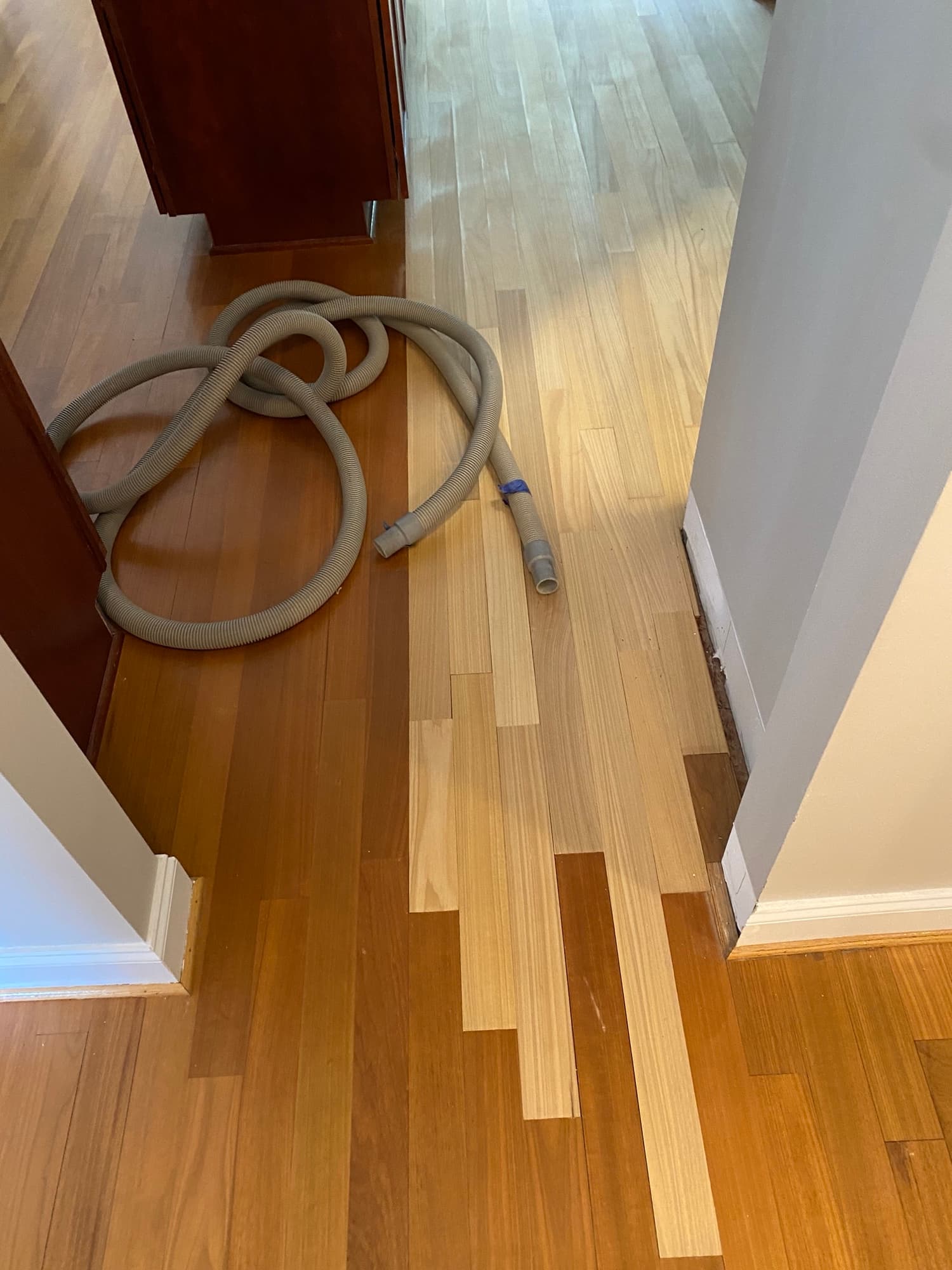 New 3 1/8 inch Brazilian oak boards being laced in on both sides of water damage repair area in Cary NC