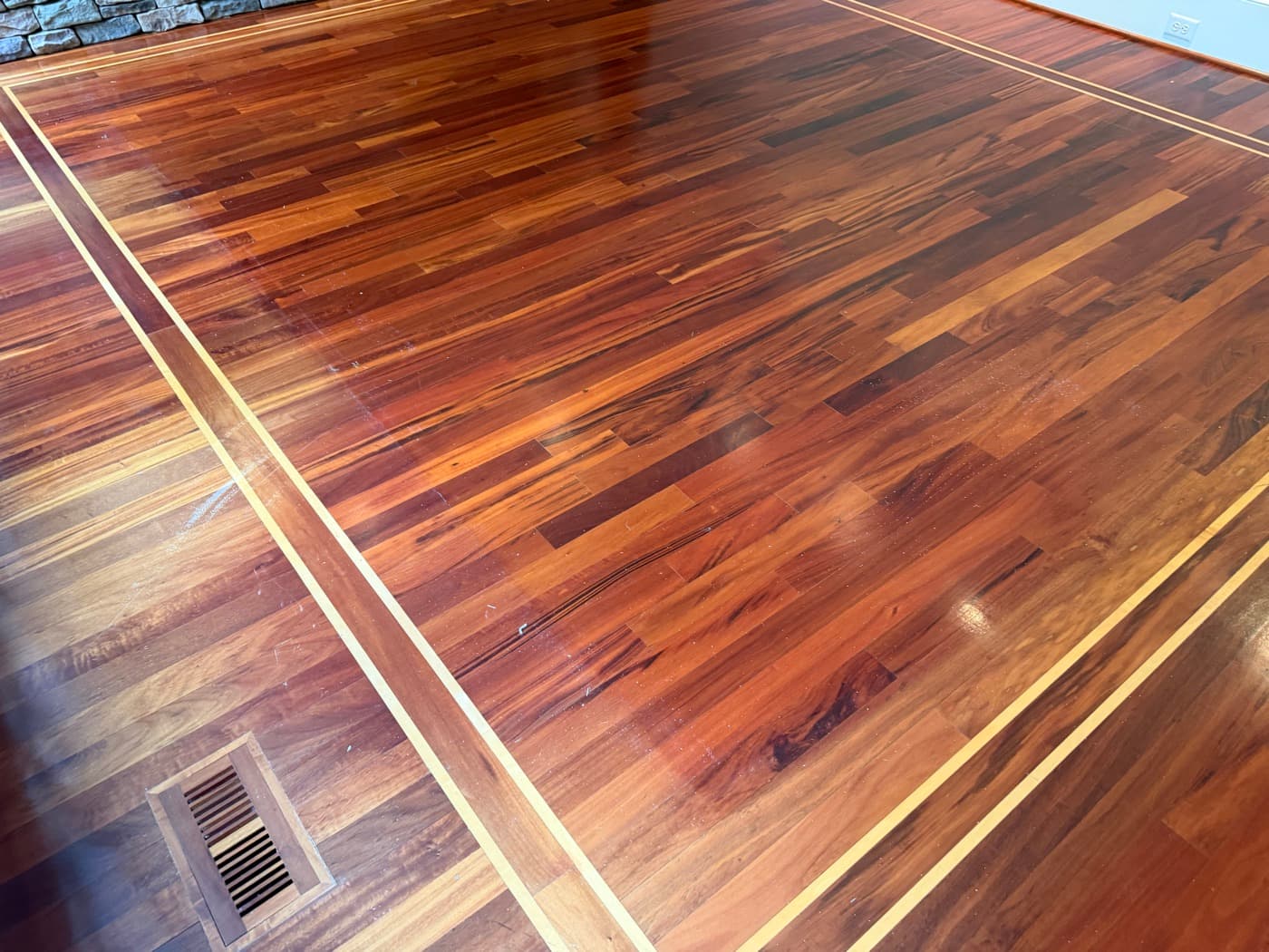 Brazilian Tigerwood family room floor with maple inlay border dulled by polish buildup before refinishing in Glen Laurel Clayton NC