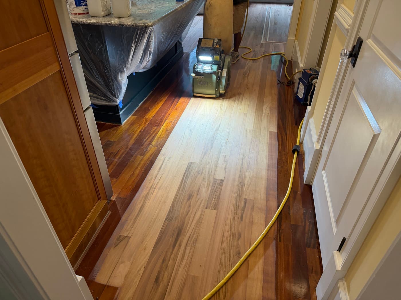 Hallway during sanding showing raw sanded Brazilian Tigerwood next to dark unsanded floor in Clayton NC