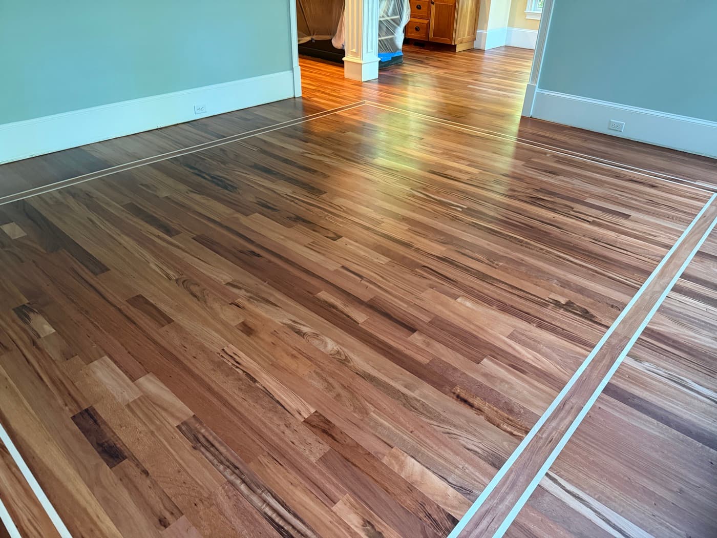Finished Brazilian Tigerwood living room floor with natural Bona Traffic HD finish and maple inlay in Glen Laurel Clayton NC