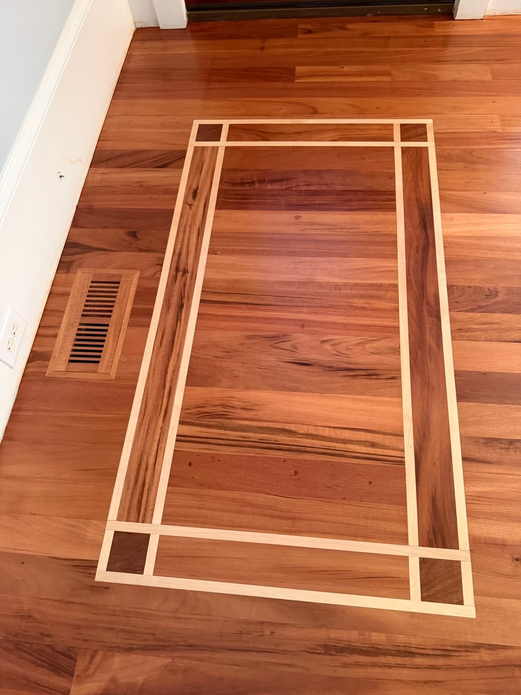 Close-up of maple inlay detail in refinished Brazilian Tigerwood entry floor in Clayton NC