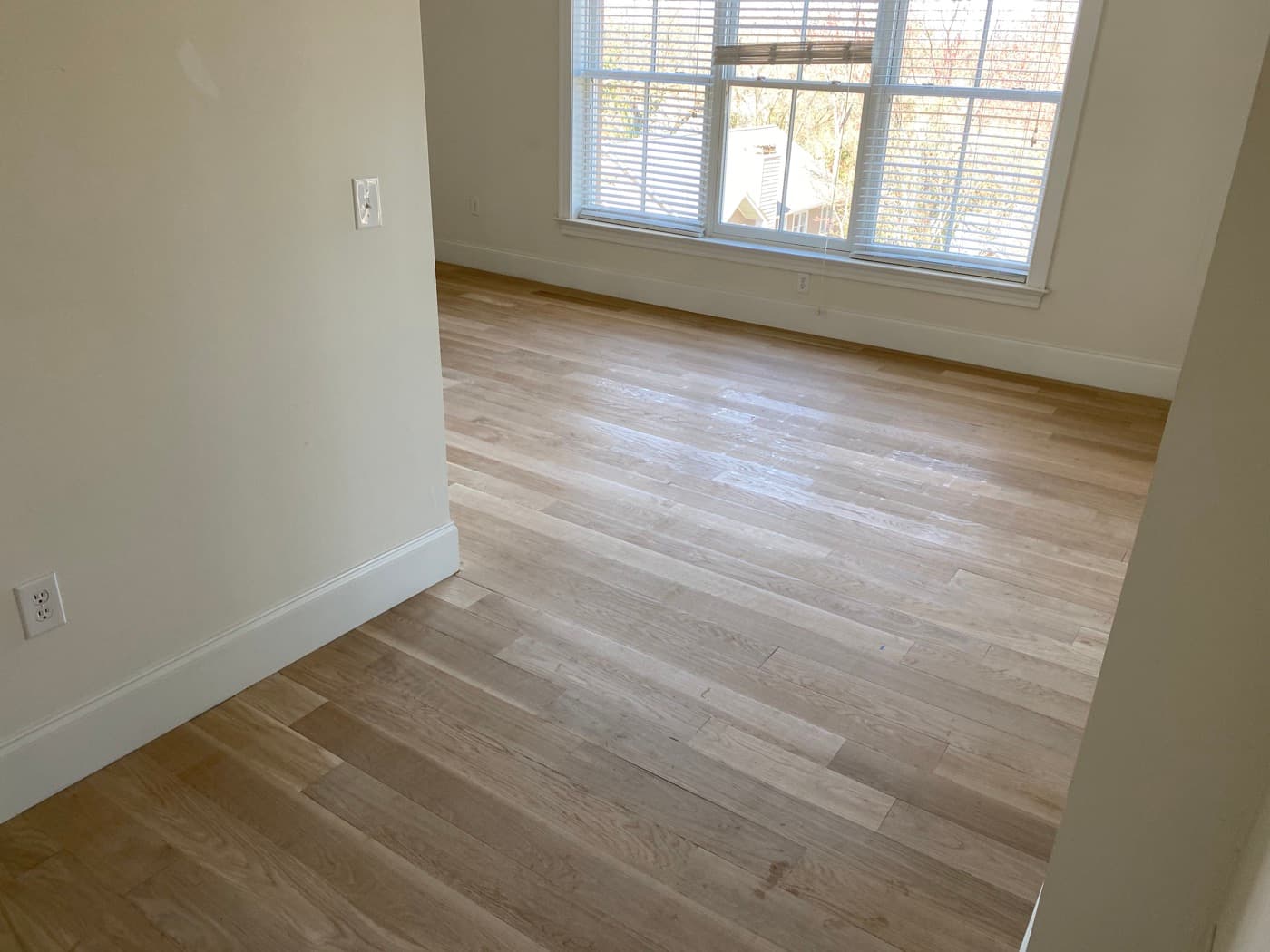 Raw unfinished engineered white oak installed and ready for sanding in bedroom