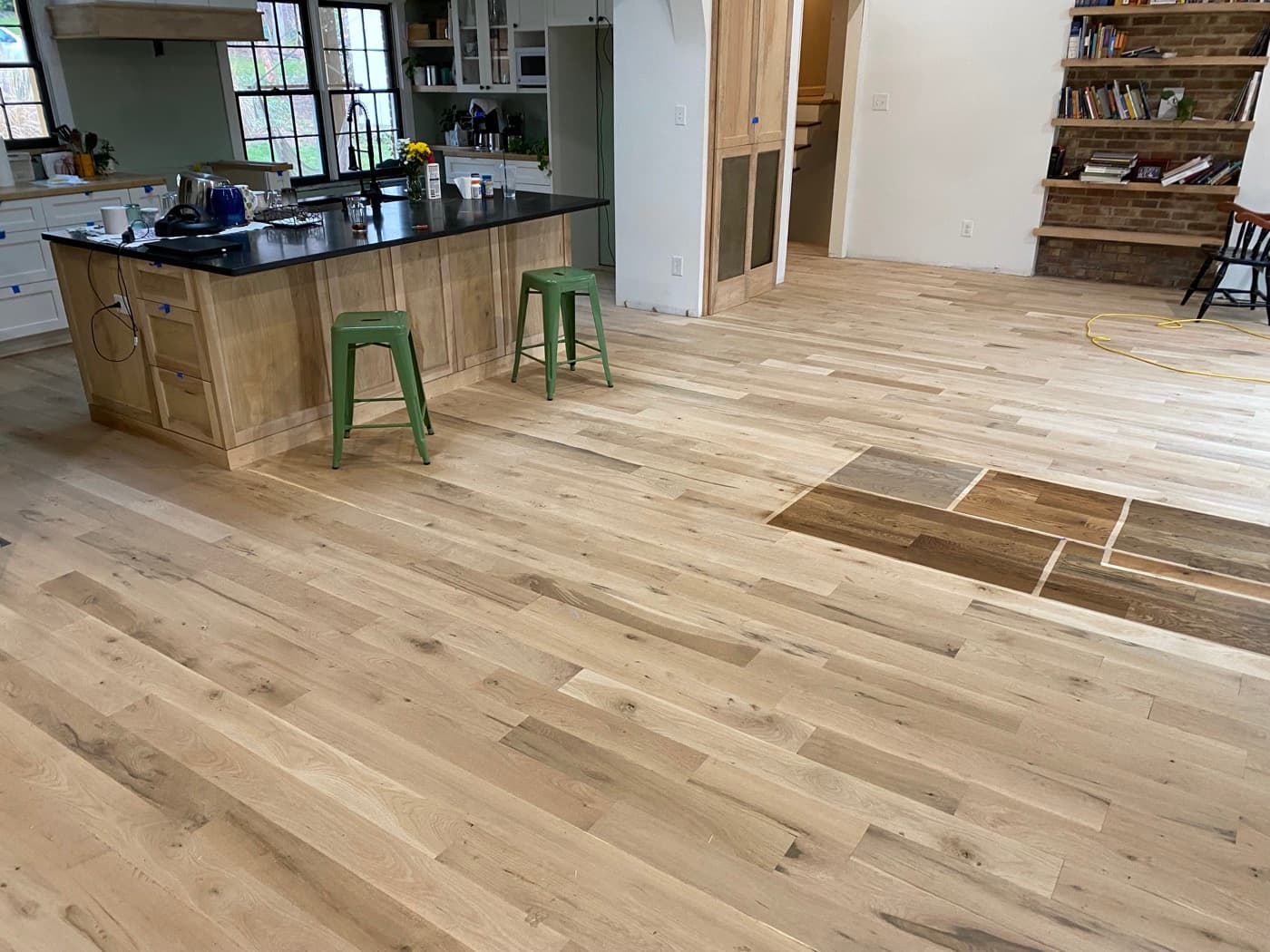 New 5-inch engineered white oak installed raw before finish in open plan kitchen and living area, Oak Park Raleigh NC