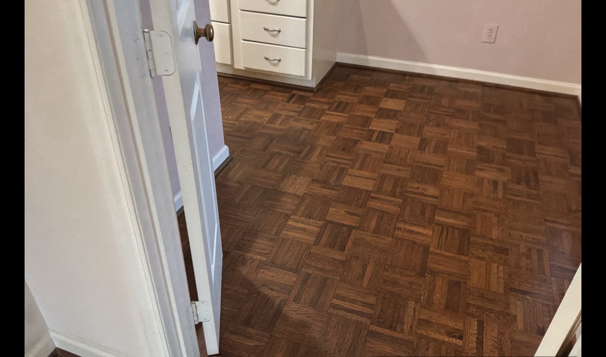 Dated dark parquet flooring in bedroom before hardwood replacement, Downtown Raleigh