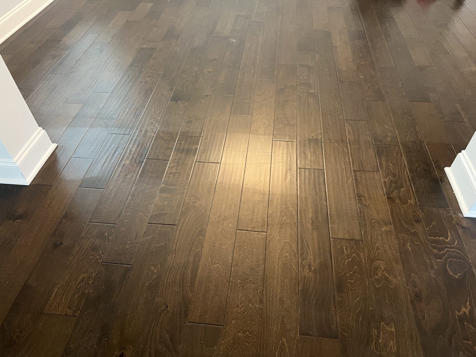 Close view of scratches and haze in the polish layer on a hand-scraped engineered floor in Fuquay-Varina NC