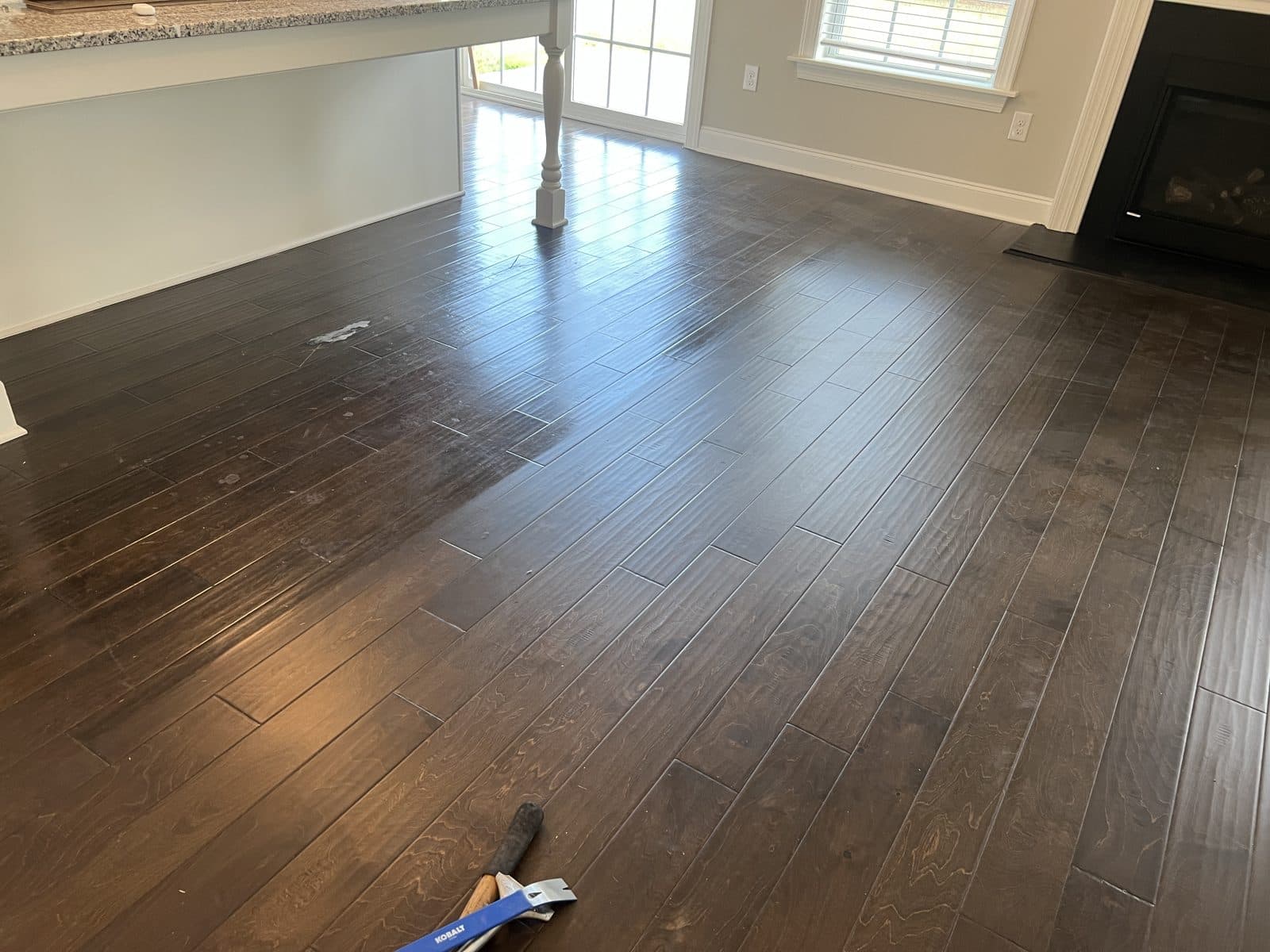 Sharp line between polished floor and the clear patch where a rug sat, before cleaning, Fuquay-Varina NC