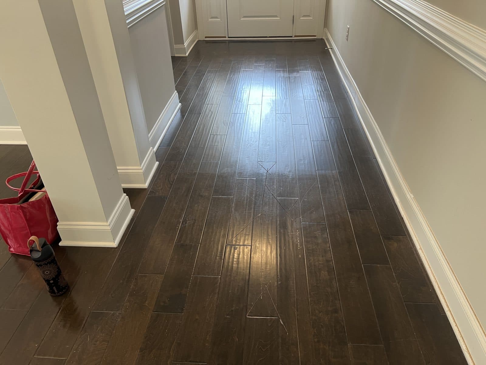 Footprints and scuffs showing in the polish film in a foyer before polish removal in Fuquay-Varina NC