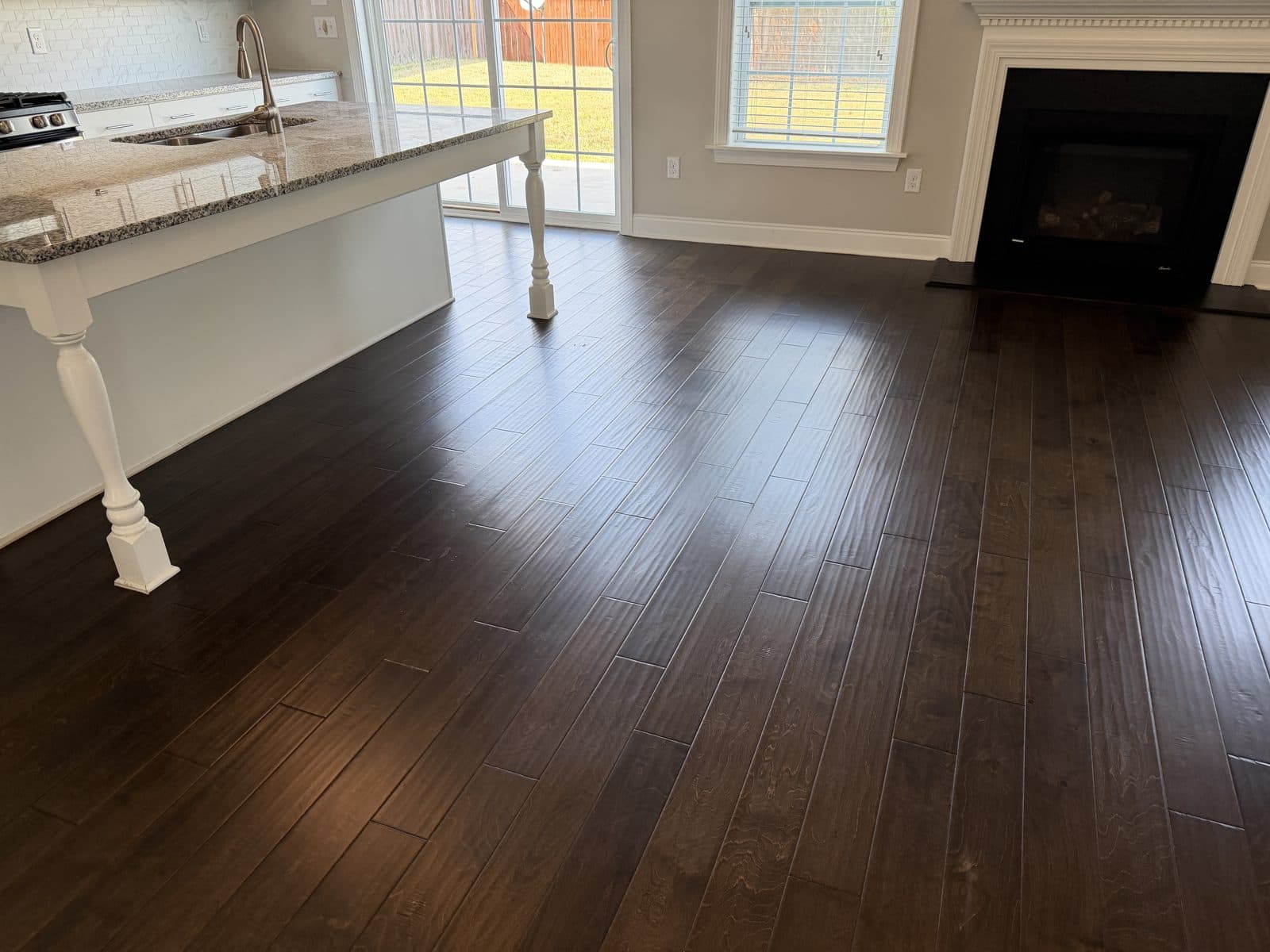 Living room and fireplace with the restored hand-scraped engineered floor after deep clean in Fuquay-Varina NC