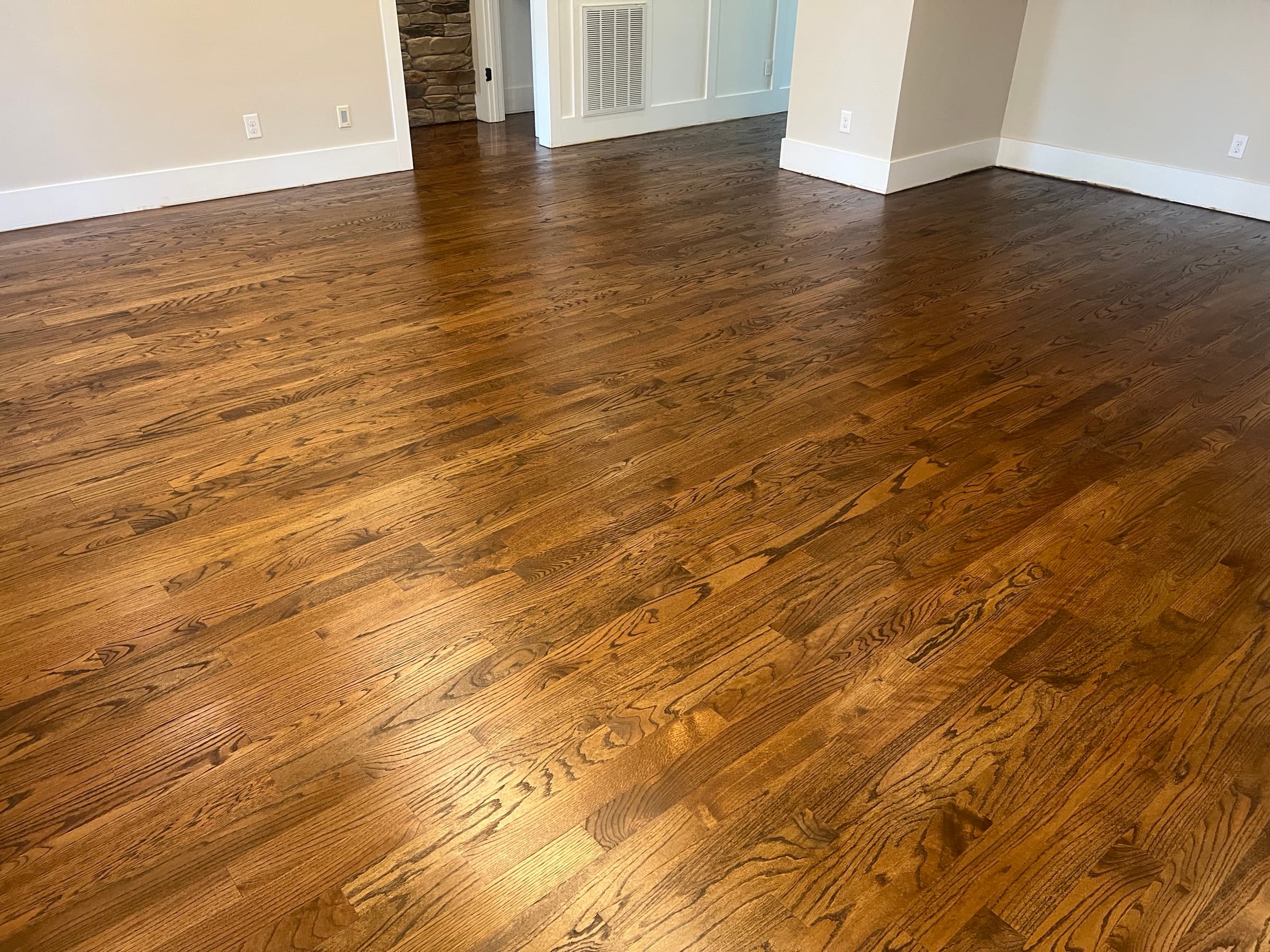 Finished red oak hardwood floors in Flowers Plantation Clayton NC, DuraSeal Medium Brown and Bona Traffic Satin, stone fireplace