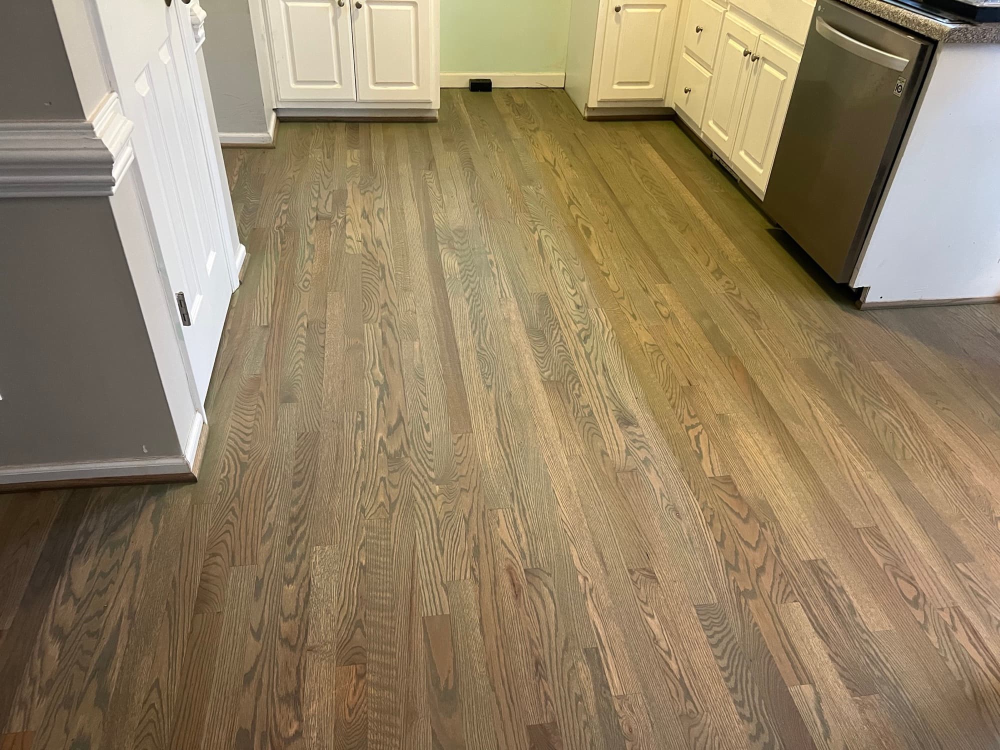 Finished red oak kitchen floor after dishwasher leak repair and custom olive brown hardwax oil refinishing in Matthews Farm Clayton NC