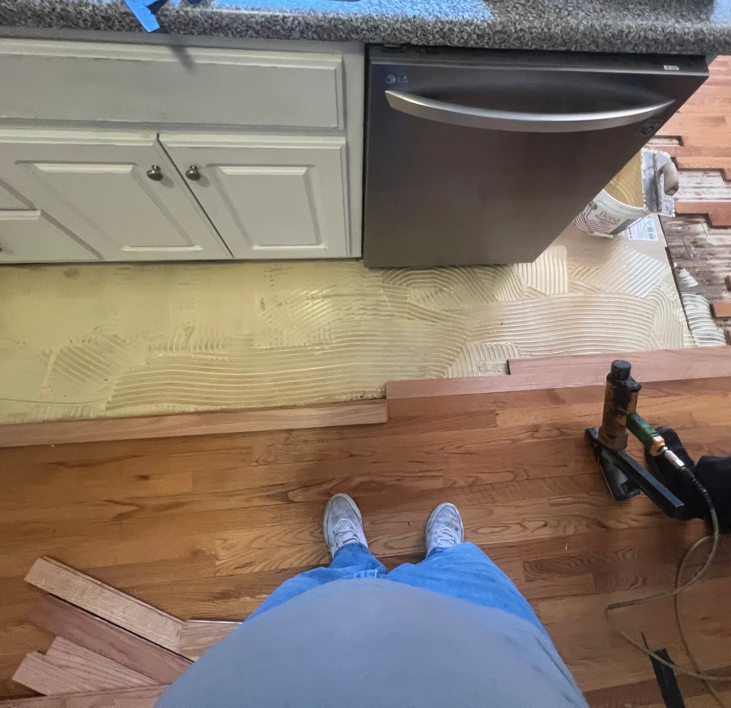 Glue and nail installation of new red oak boards under dishwasher area in Matthews Farm Clayton NC kitchen repair