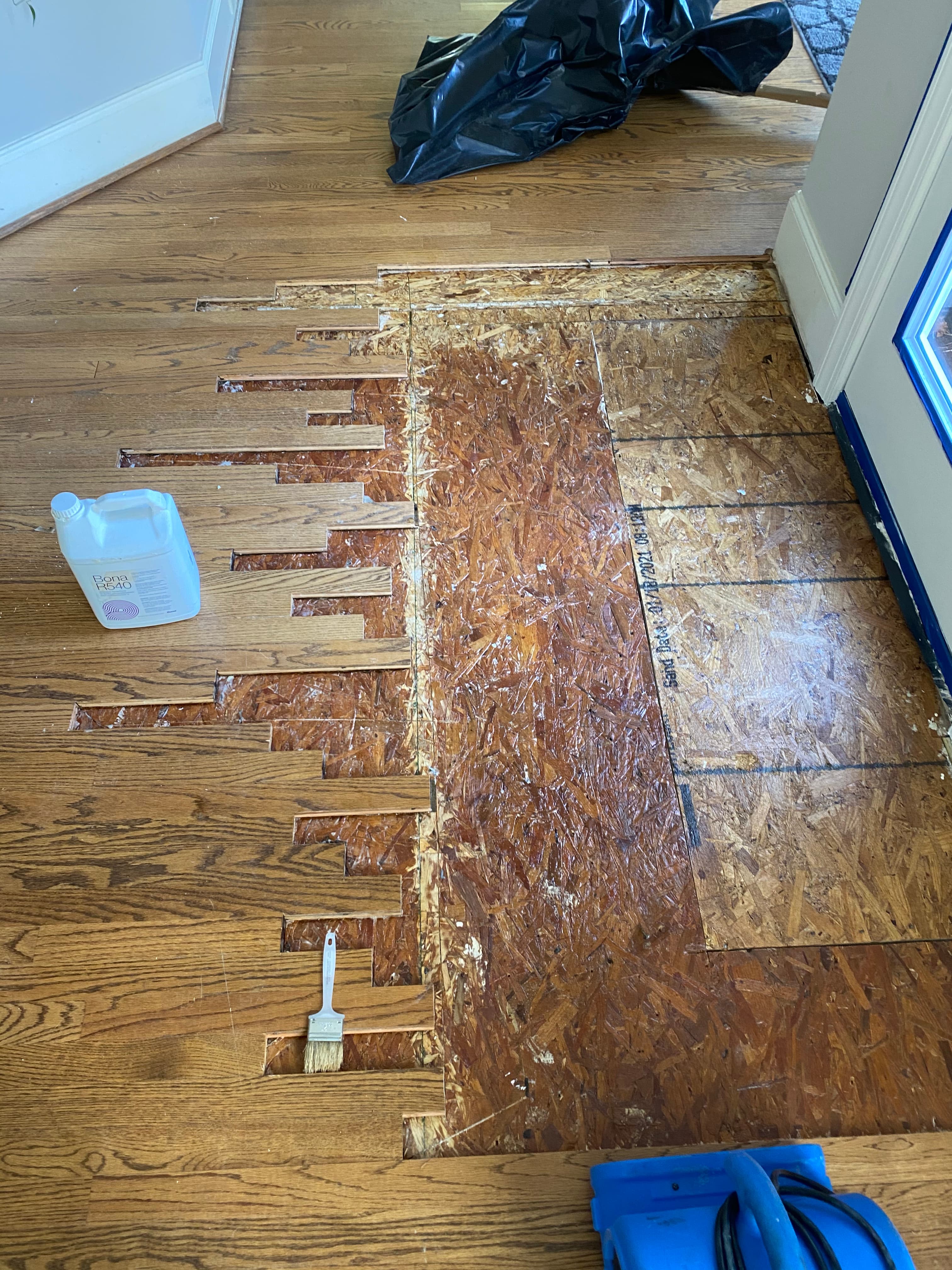 Bona R540 moisture barrier applied and new red oak boards going in during repair at Hocutt Farm Clayton NC, staggered board cuts at repair boundary