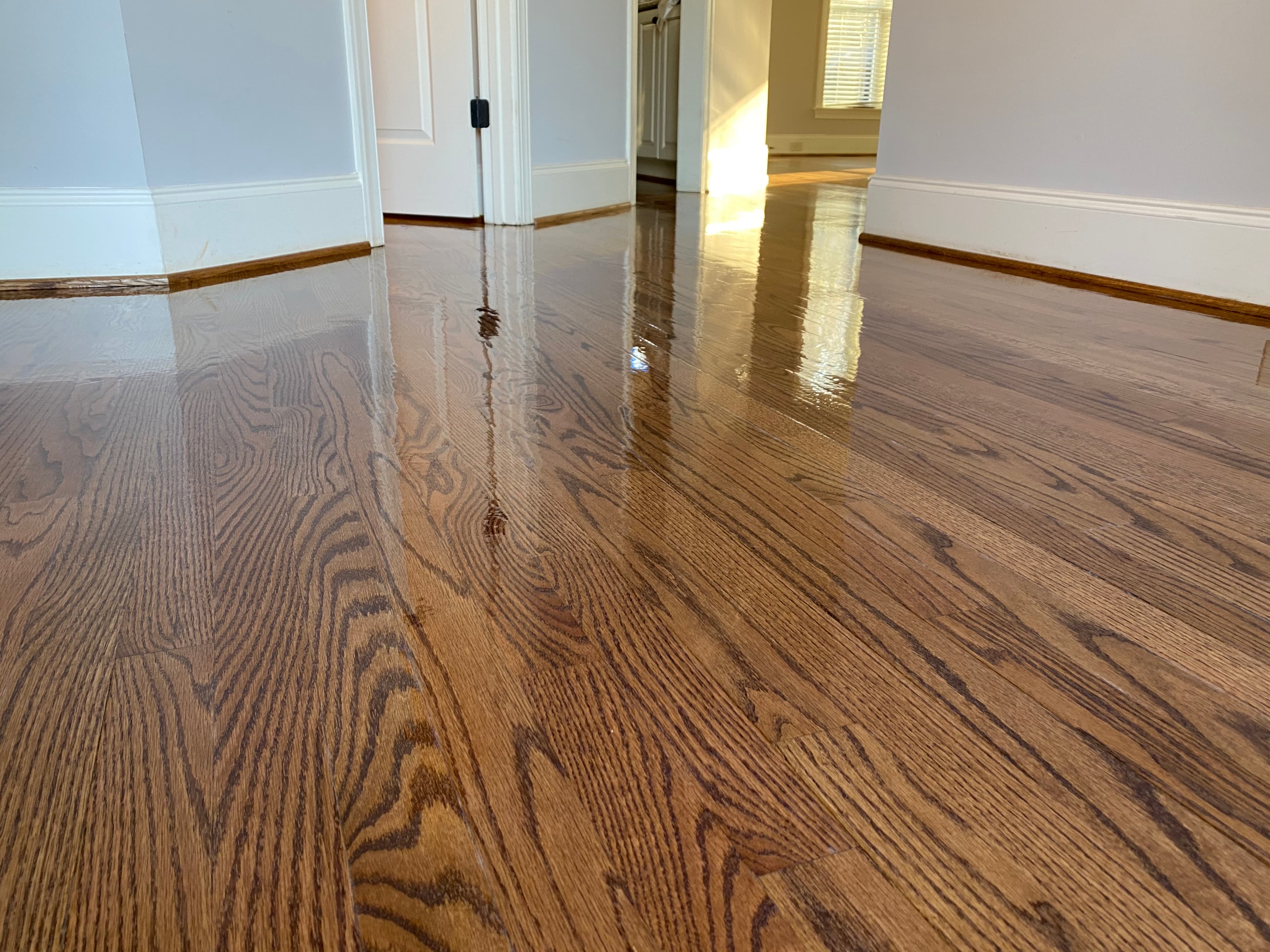 Finished red oak floors throughout Hocutt Farm Clayton NC after full refinish, custom DuraSeal blend, Bona Traffic HD, rooms visible through doorways