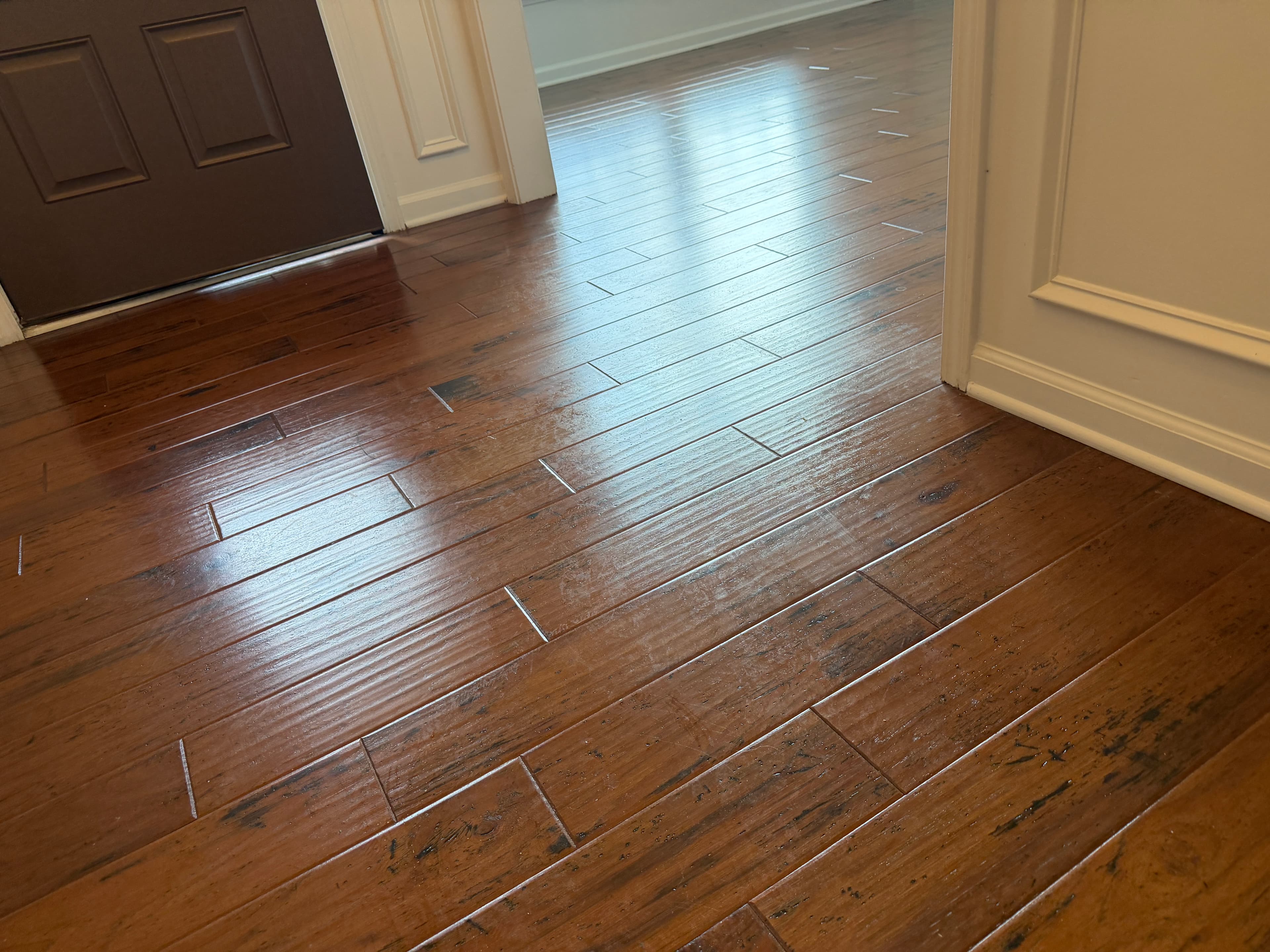 Consumer polish buildup and traffic wear in hickory entryway before deep clean in Holly Springs NC