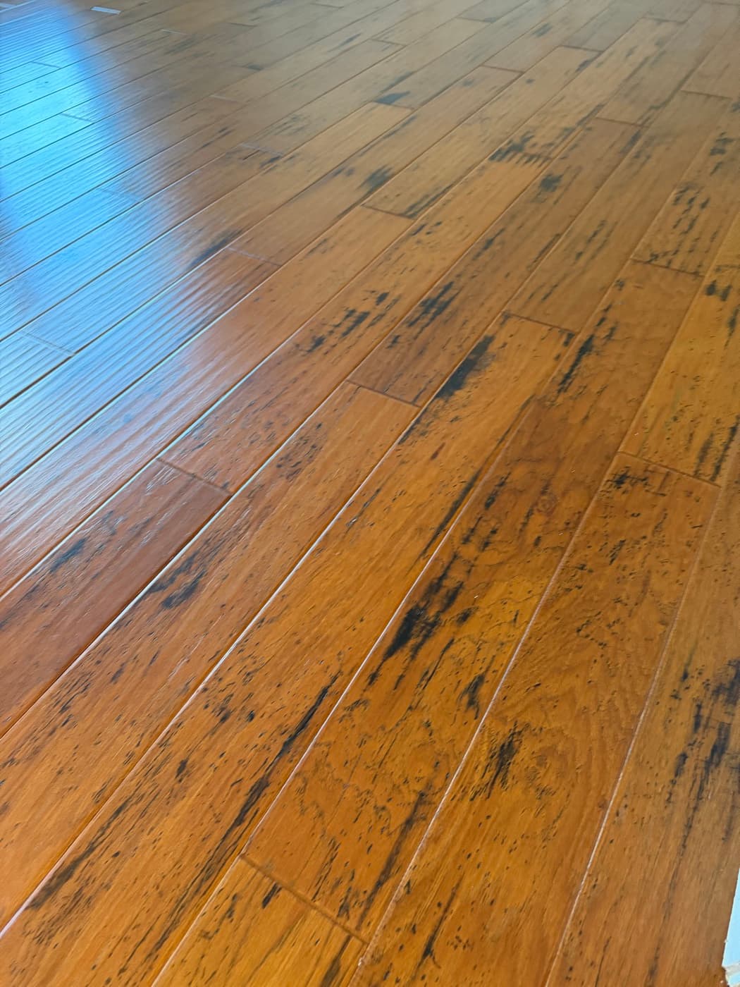 Hand-scraped hickory hardwood floor texture detail in Holly Springs NC showing the busy grain that hides wear on the hardest domestic species