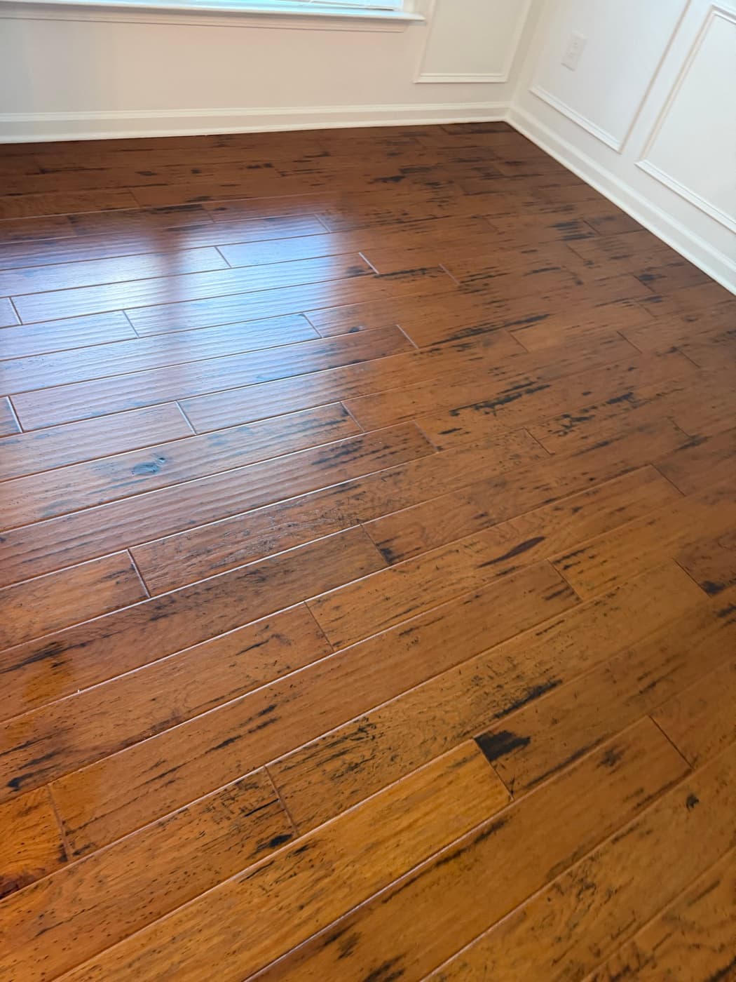 Clean hand-scraped hickory floor in dining room with wainscoting after deep clean in Holly Springs NC