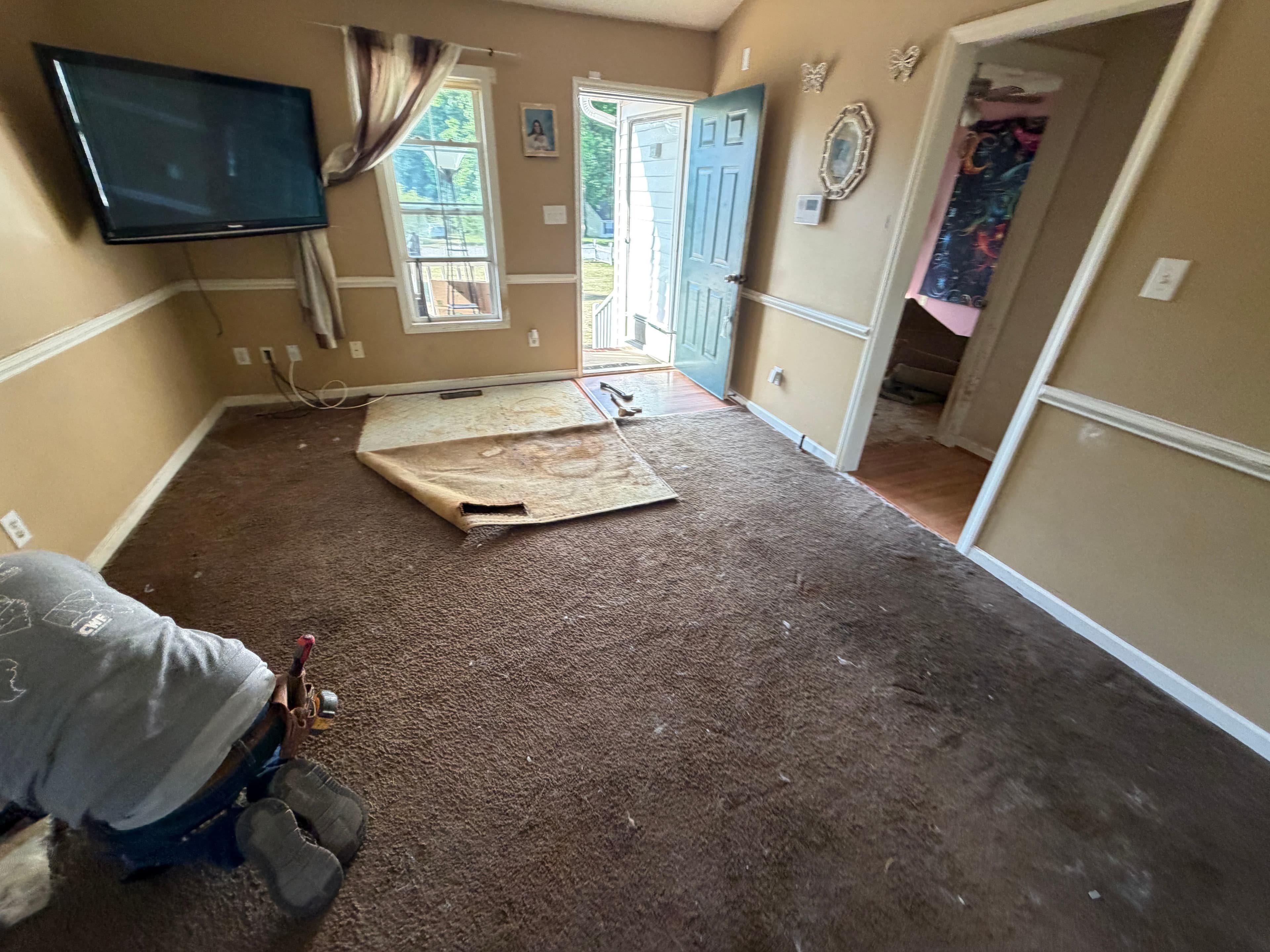Original carpet in family room before LVP installation in Buffalo Creek Zebulon NC, worn flooring throughout main living area