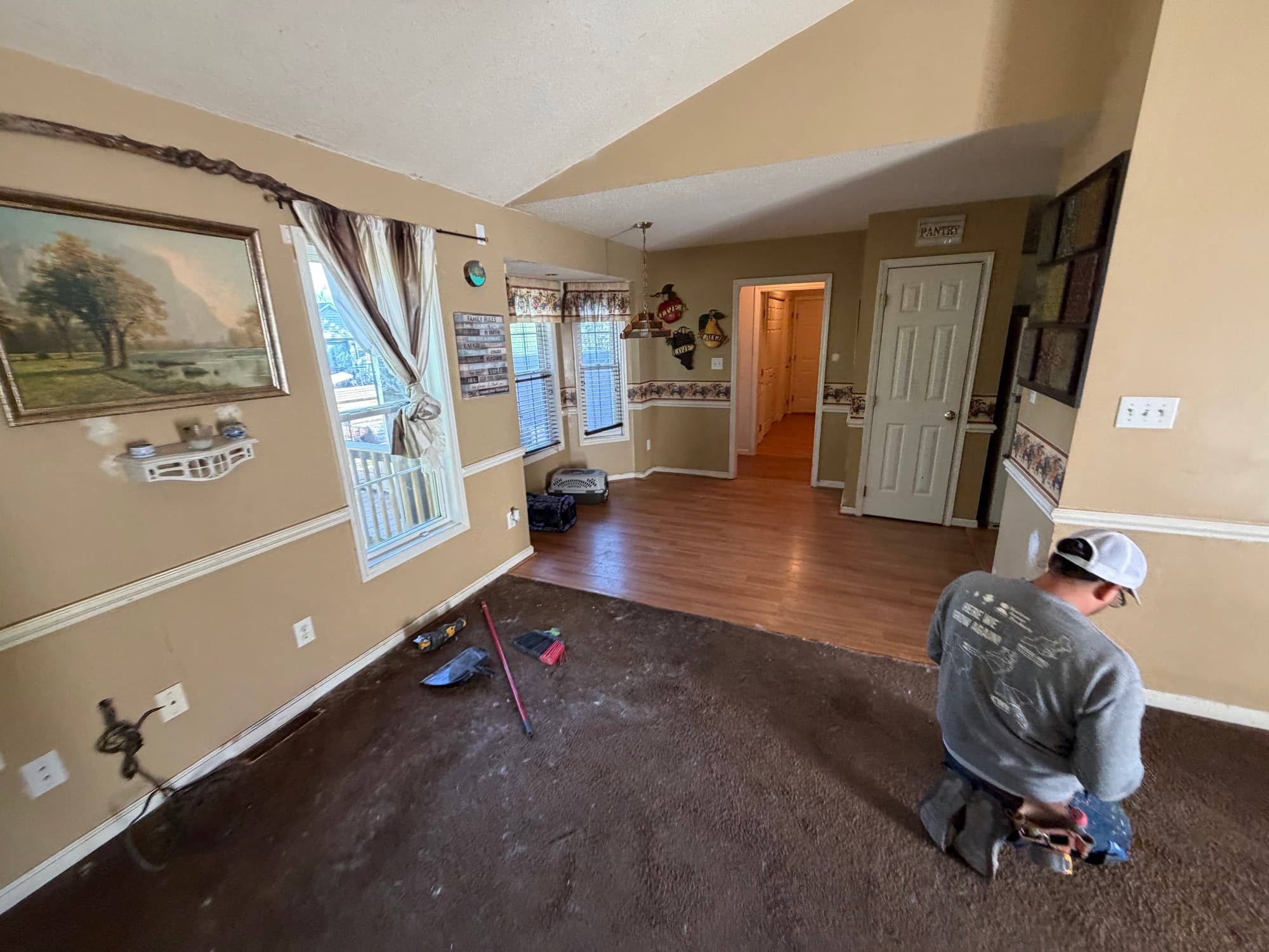 Laminate flooring in kitchen area before demo in Buffalo Creek Zebulon NC home, existing flooring staged for removal