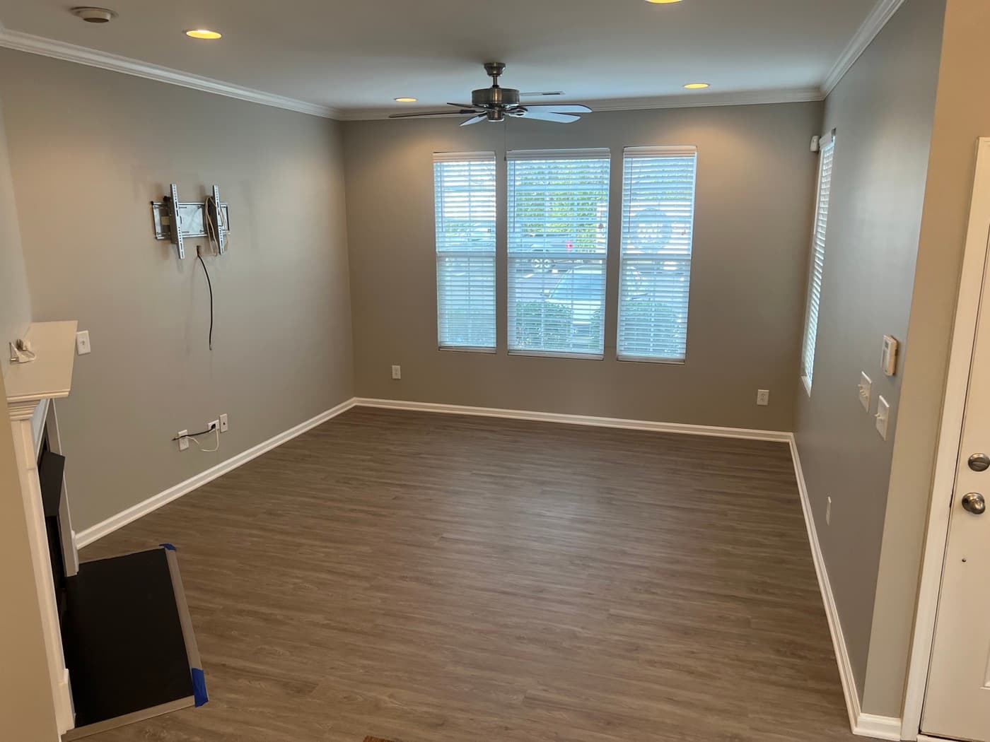 Finished gray LVP flooring installed over existing engineered hardwood in Miriah Towns townhouse, Garner NC, wide living room view