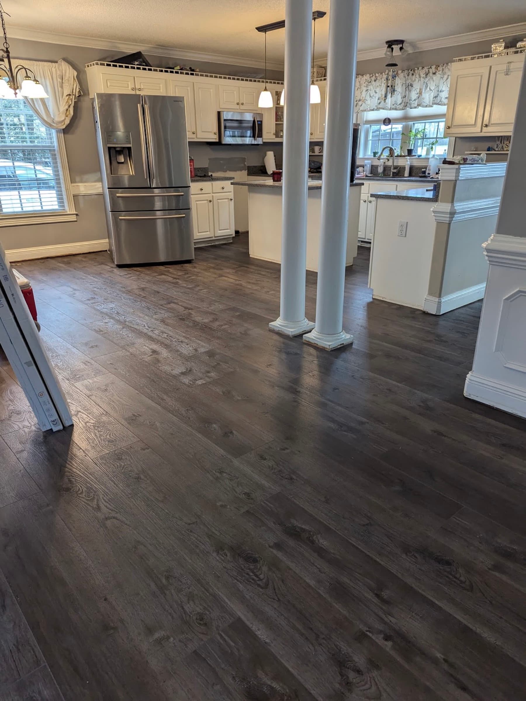 Finished Innova SPC Pearl River flooring throughout open concept kitchen and living area in Winston Plantation Clayton NC with white columns