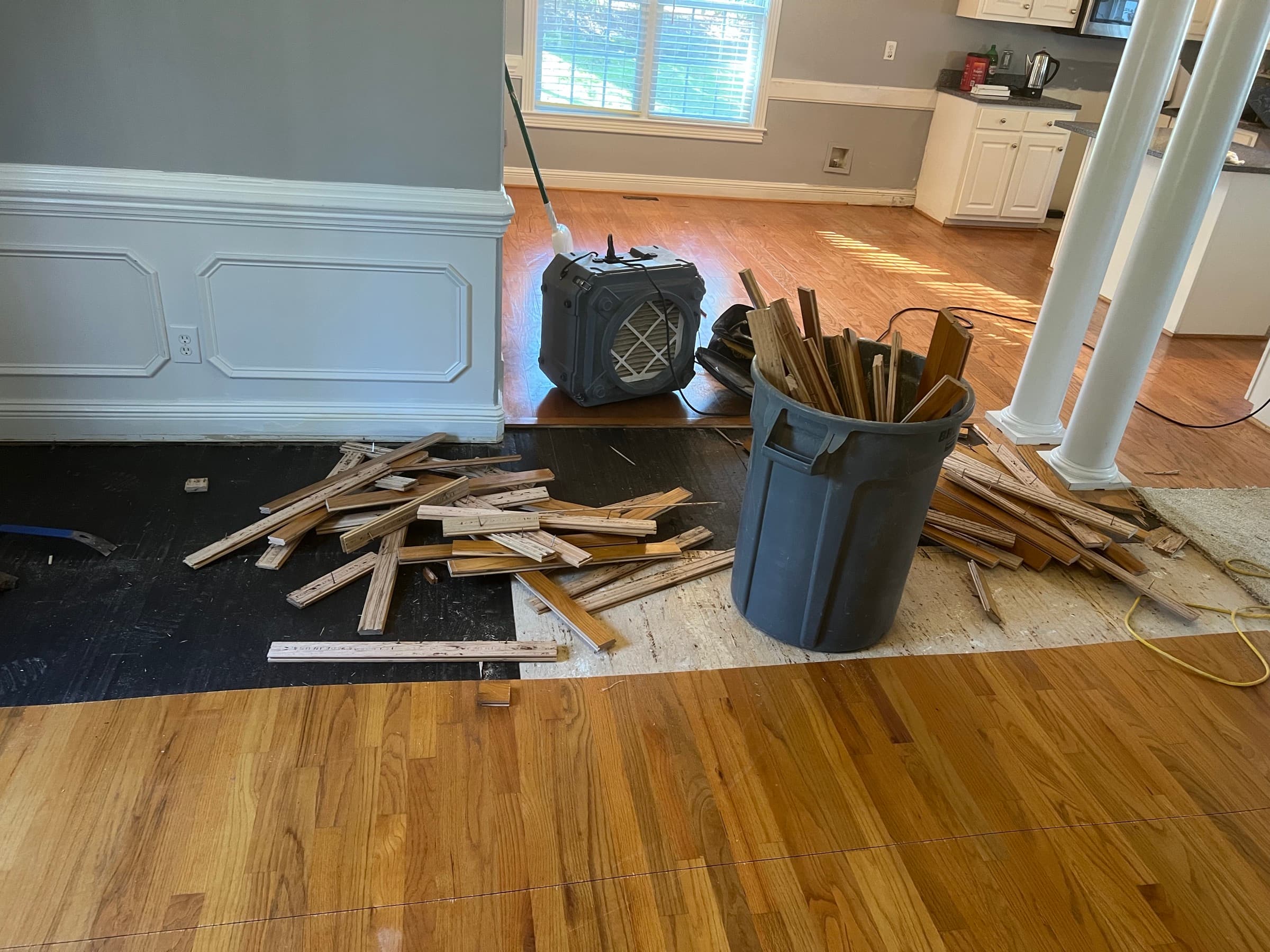 Hardwood floor demo in progress in Winston Plantation Clayton NC, boards ripped out and subfloor exposed
