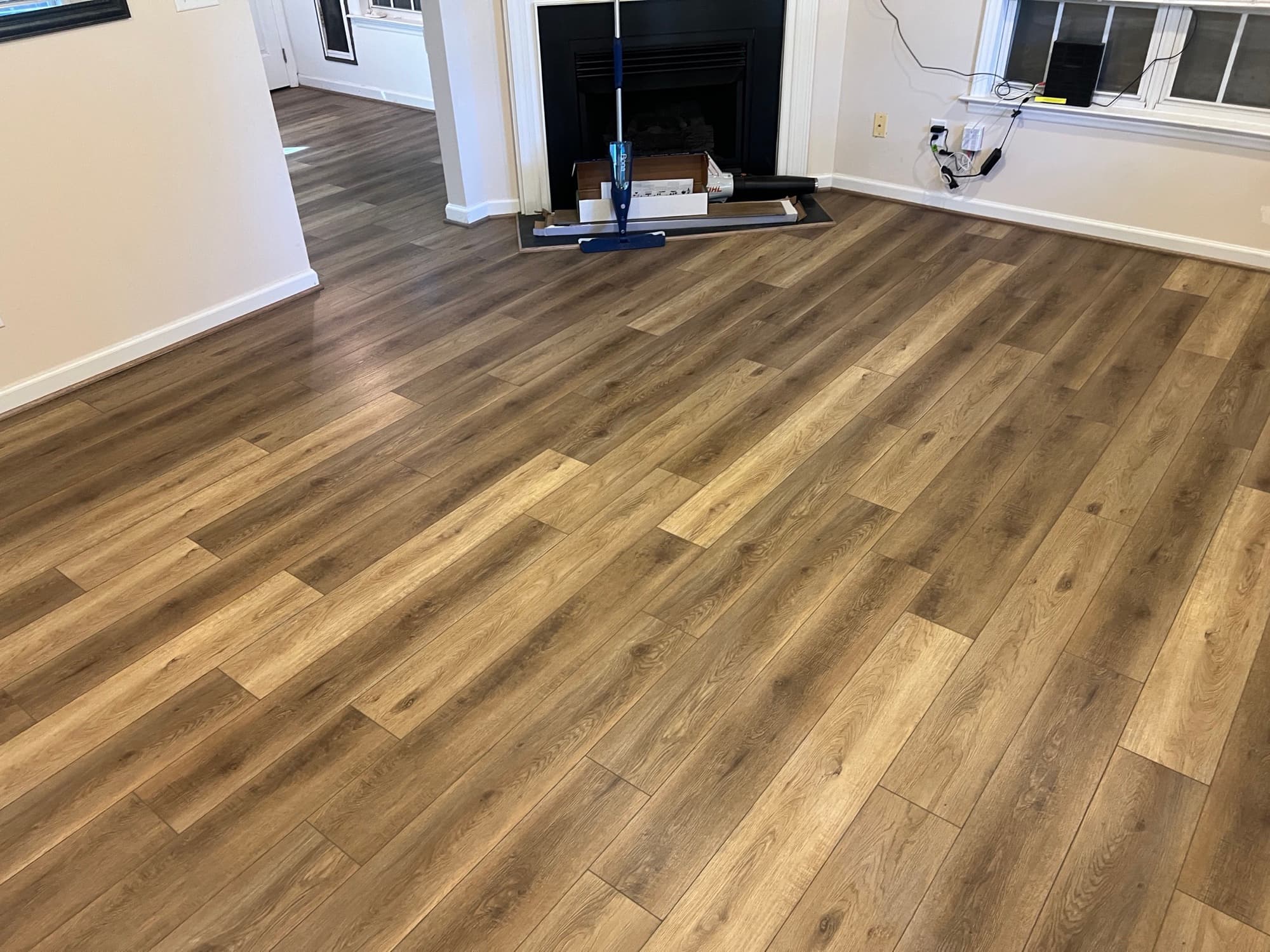 Finished Choice Flooring LVP Vineyard Chardonnay in living room with fireplace in Zebulon NC home after mold remediation and installation