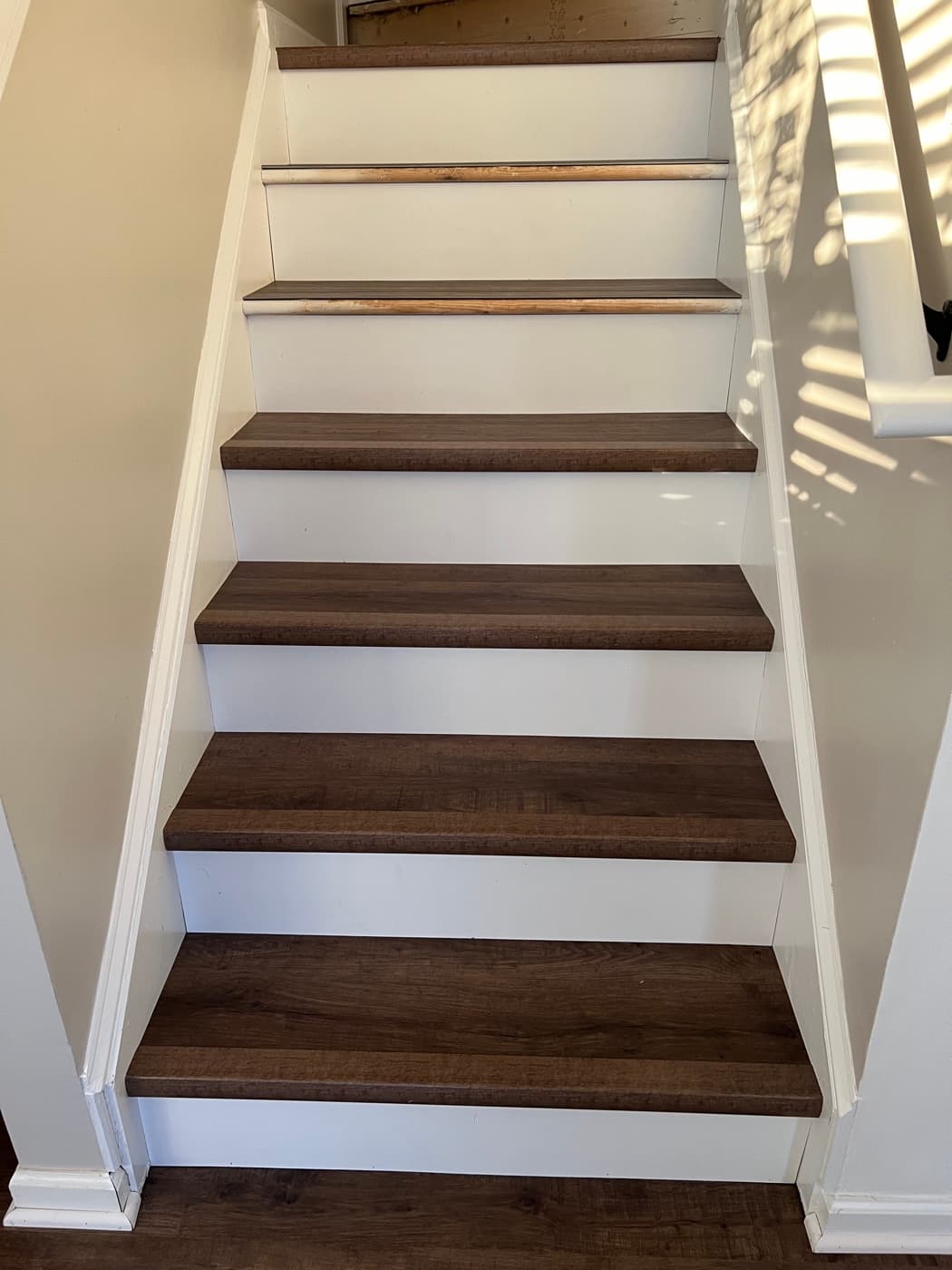 Finished LVP stair treads with white painted risers after carpet removal in Tuscany Clayton NC