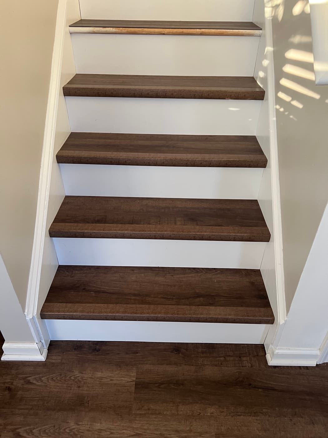 Finished LVP stair treads with white painted risers matching main-level LVP flooring in Tuscany Clayton NC