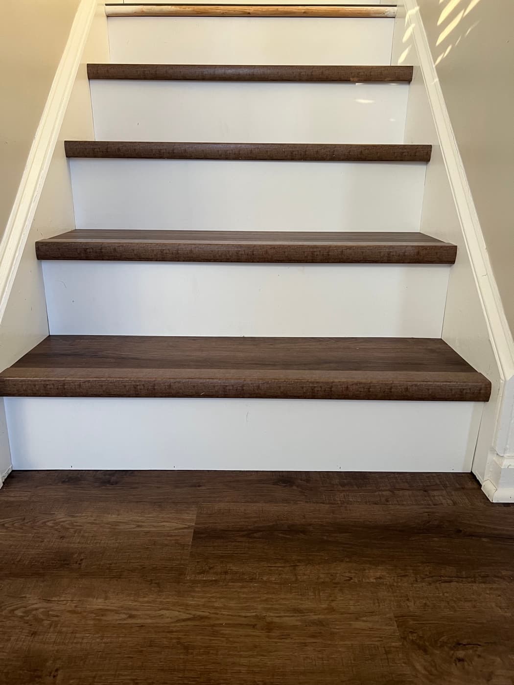 Close-up of finished LVP stair treads and white painted risers in Tuscany Clayton NC