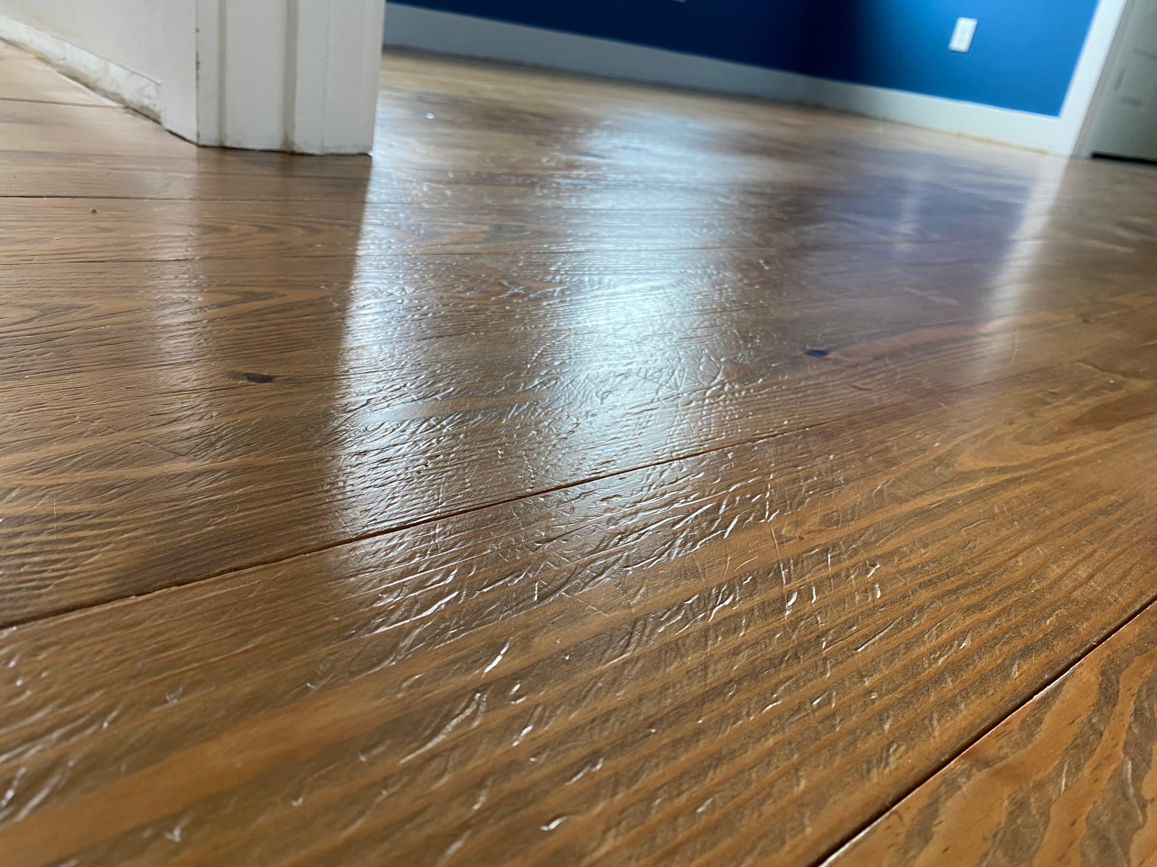 Wide plank pine floor before sanding in Flowers Plantation Clayton NC, showing wear and original finish condition
