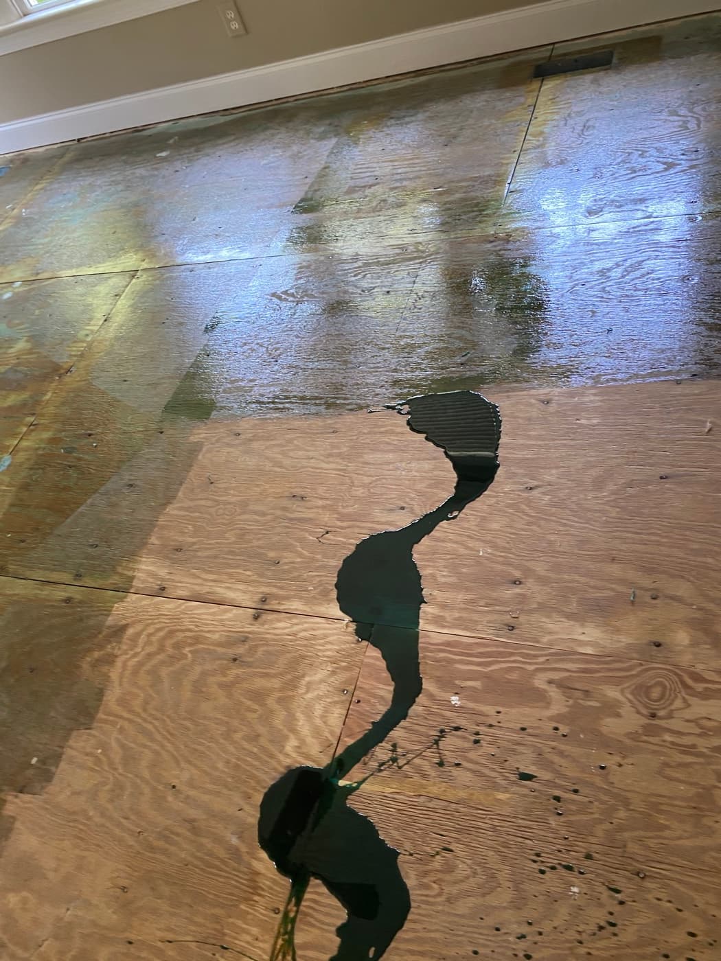 Wakol PU 280 moisture barrier being applied to plywood subfloor before hardwood installation at Sunset Lakes Fuquay-Varina NC