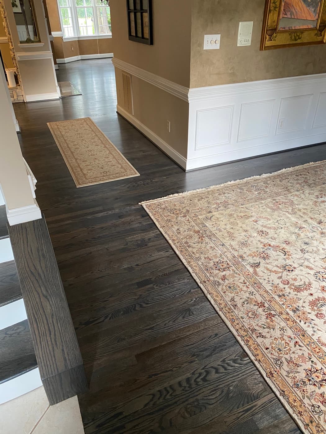 Finished open plan living area with Bona Driftwood red oak floors and area rugs back in place at Sunset Lakes Fuquay-Varina NC