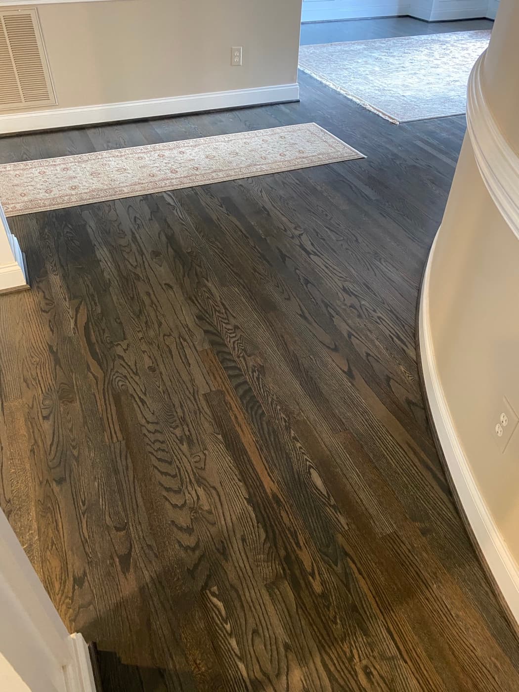 Finished Bona Driftwood red oak floor in foyer under curved arch entrance at Sunset Lakes Fuquay-Varina NC