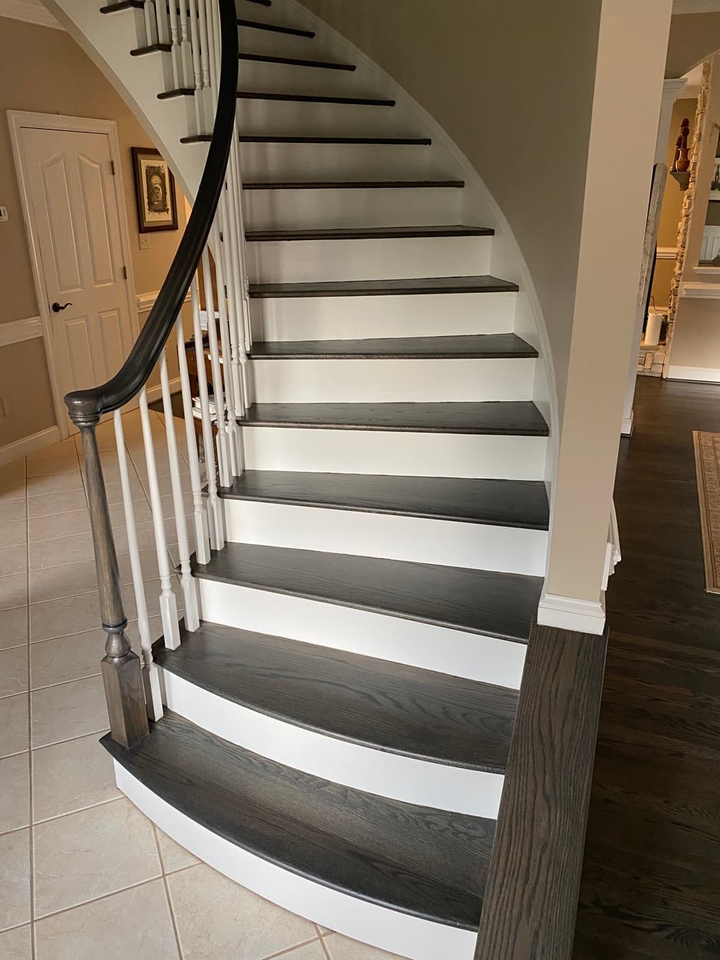 Finished curved staircase with Bona Driftwood stained red oak treads viewed from above at Sunset Lakes Fuquay-Varina NC