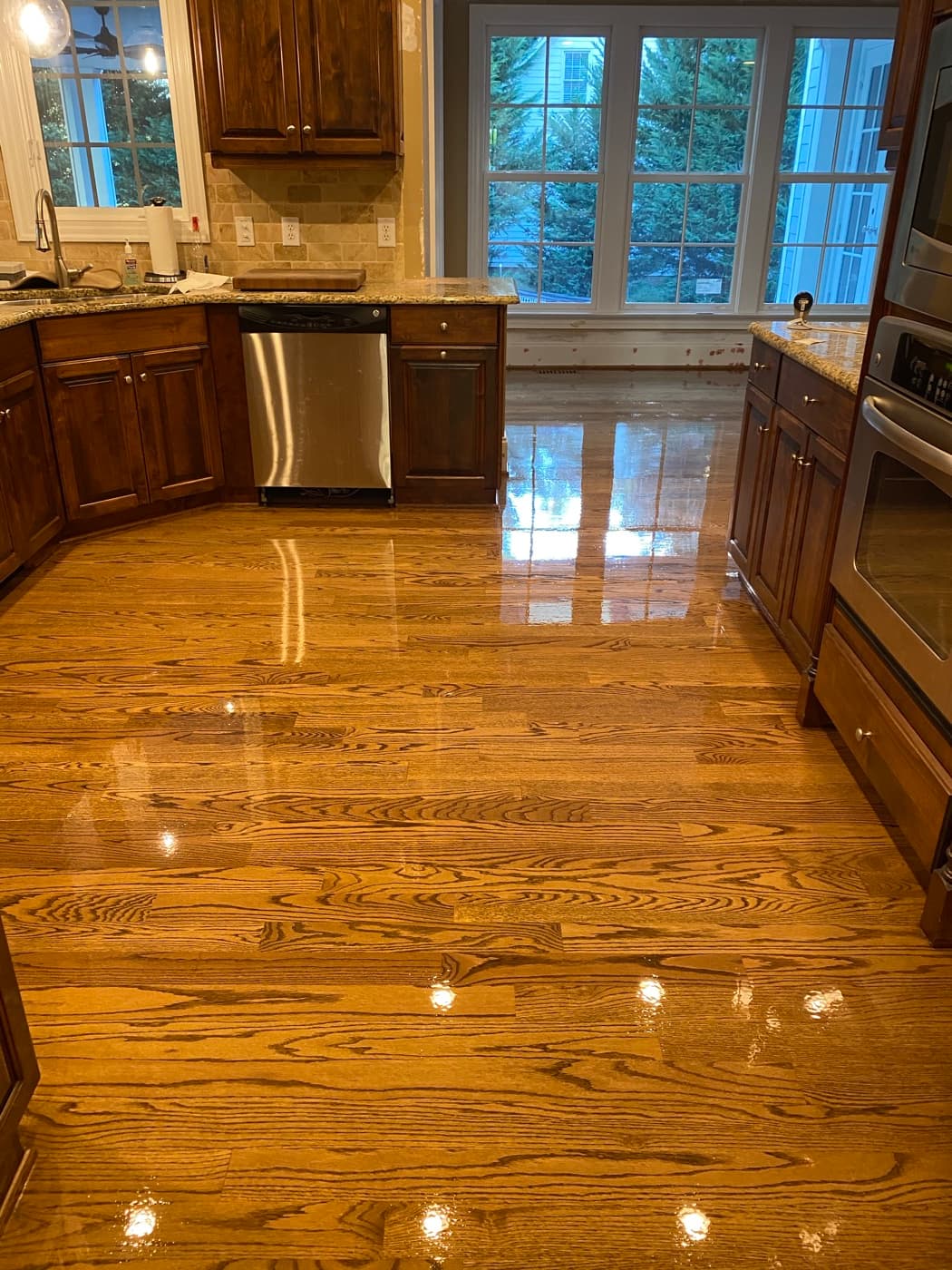 Angled view of finished red oak floors with DuraSeal Special Walnut stain and Bona Traffic HD in kitchen, Crabtree Heights Raleigh NC