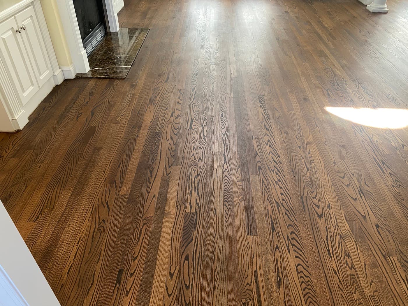 Red oak hardwood floors finished with custom Rubio Monocoat 2C dark warm brown in living room at Tanner's Creek Wendell NC