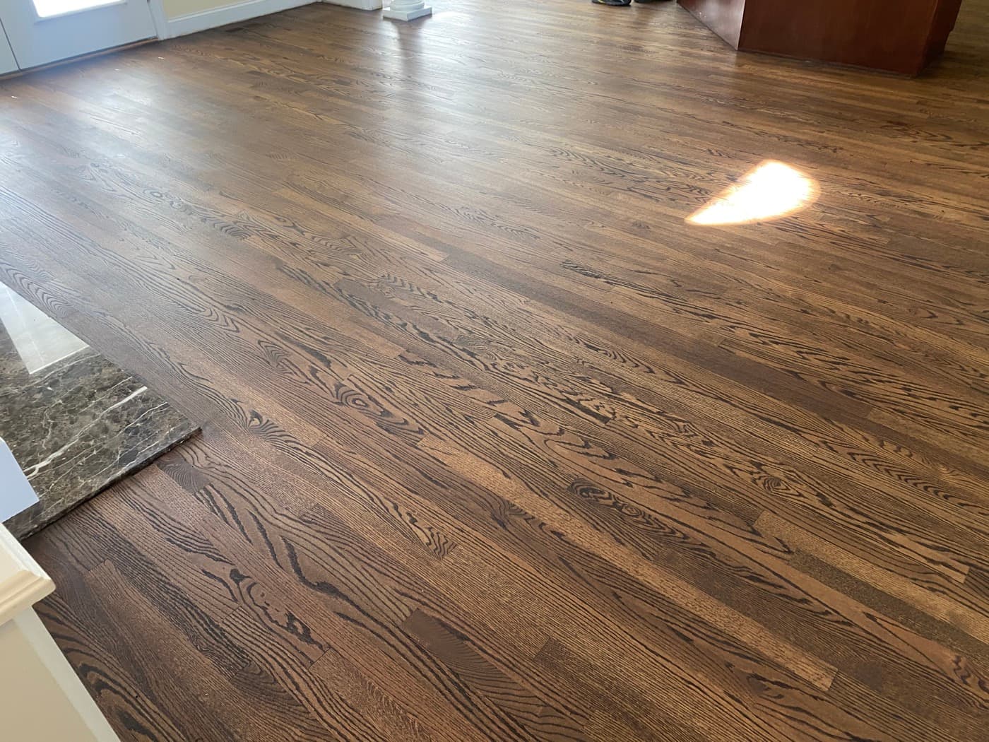 Open plan main level with custom Rubio Monocoat 2C dark brown red oak hardwood floors at Tanner's Creek Wendell NC