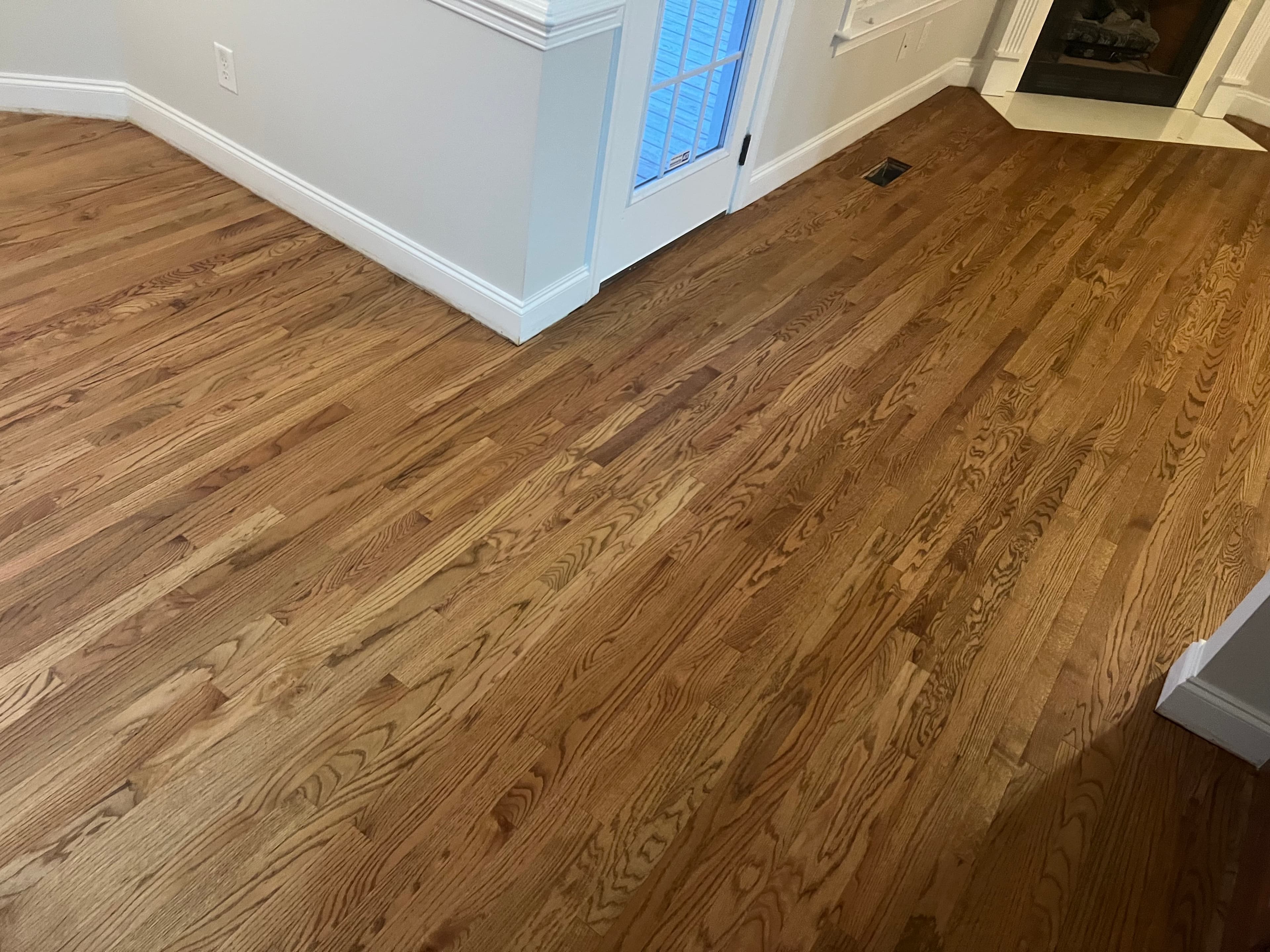 Finished red oak floor near fireplace surround in Summerset Place Clayton NC, custom Berger Seidle hardwax oil warm brown matte finish