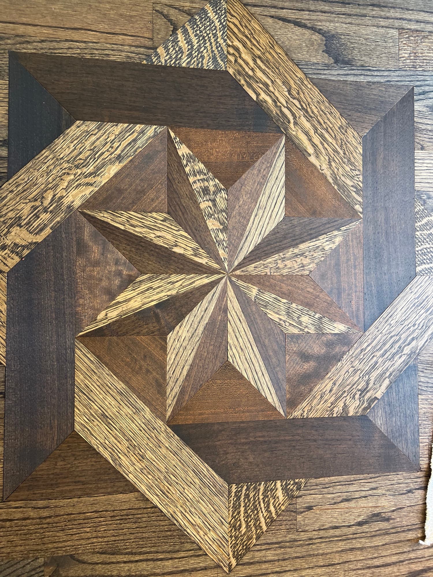 Refinished hardwood floor inlay star medallion in Austin Pond Clayton NC, custom hardwax oil blend bringing out dramatic species contrast in geometric star pattern