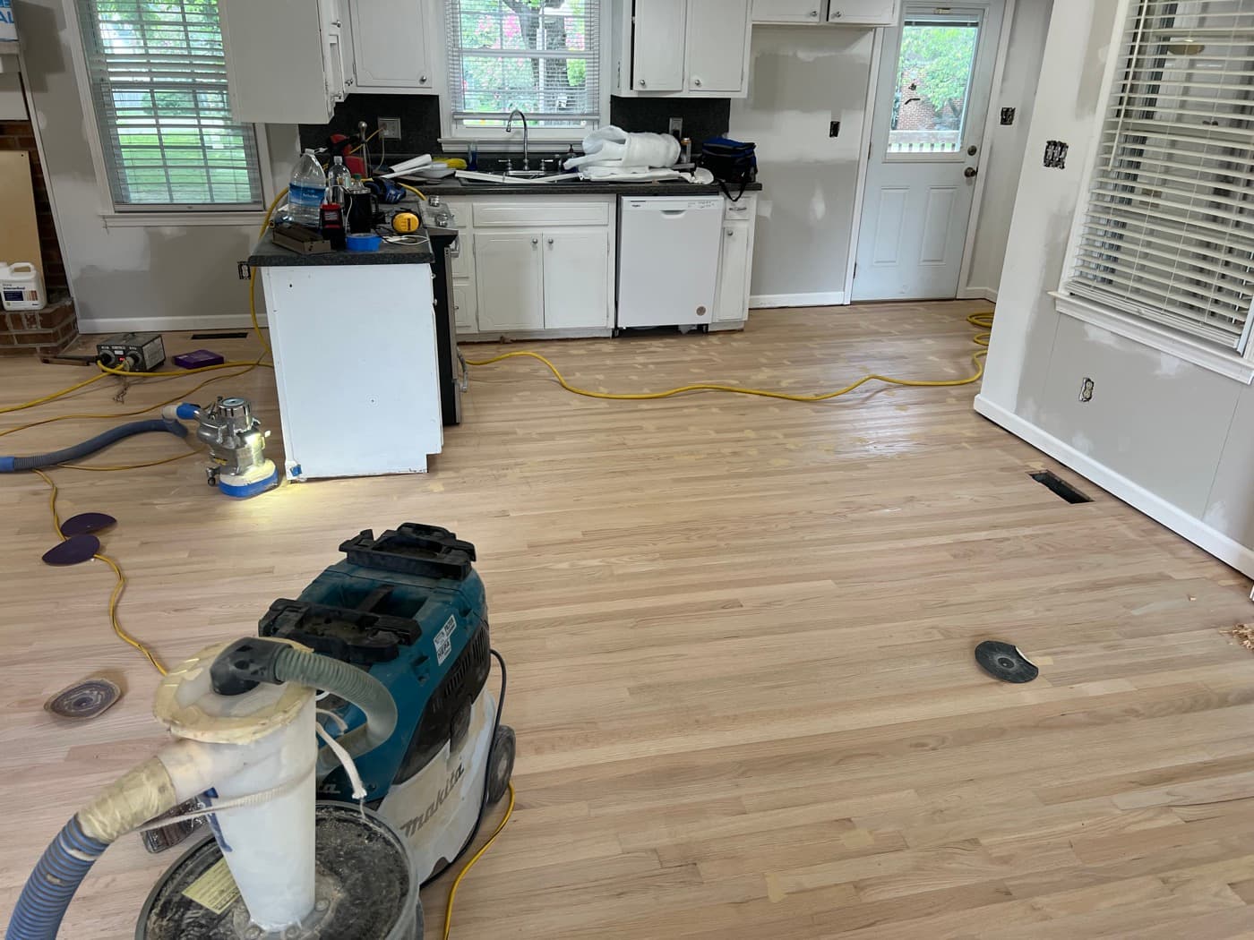 Red oak floor sanded bare in kitchen during refinishing in Knightdale NC, open plan kitchen and living area