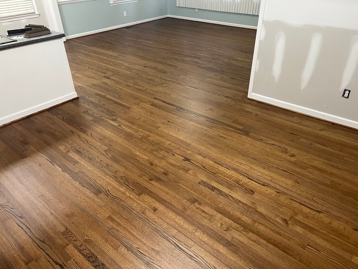 Wide view of finished red oak floors in kitchen and living room with DuraSeal Provincial in Downtown Knightdale NC