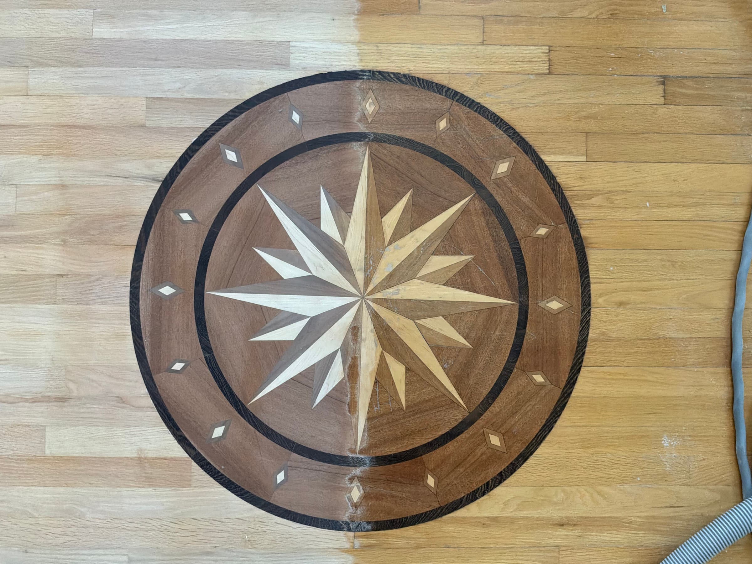 Compass rose medallion mid-sanding in Glen Laurel Clayton NC, old finish on right and bare wood on left