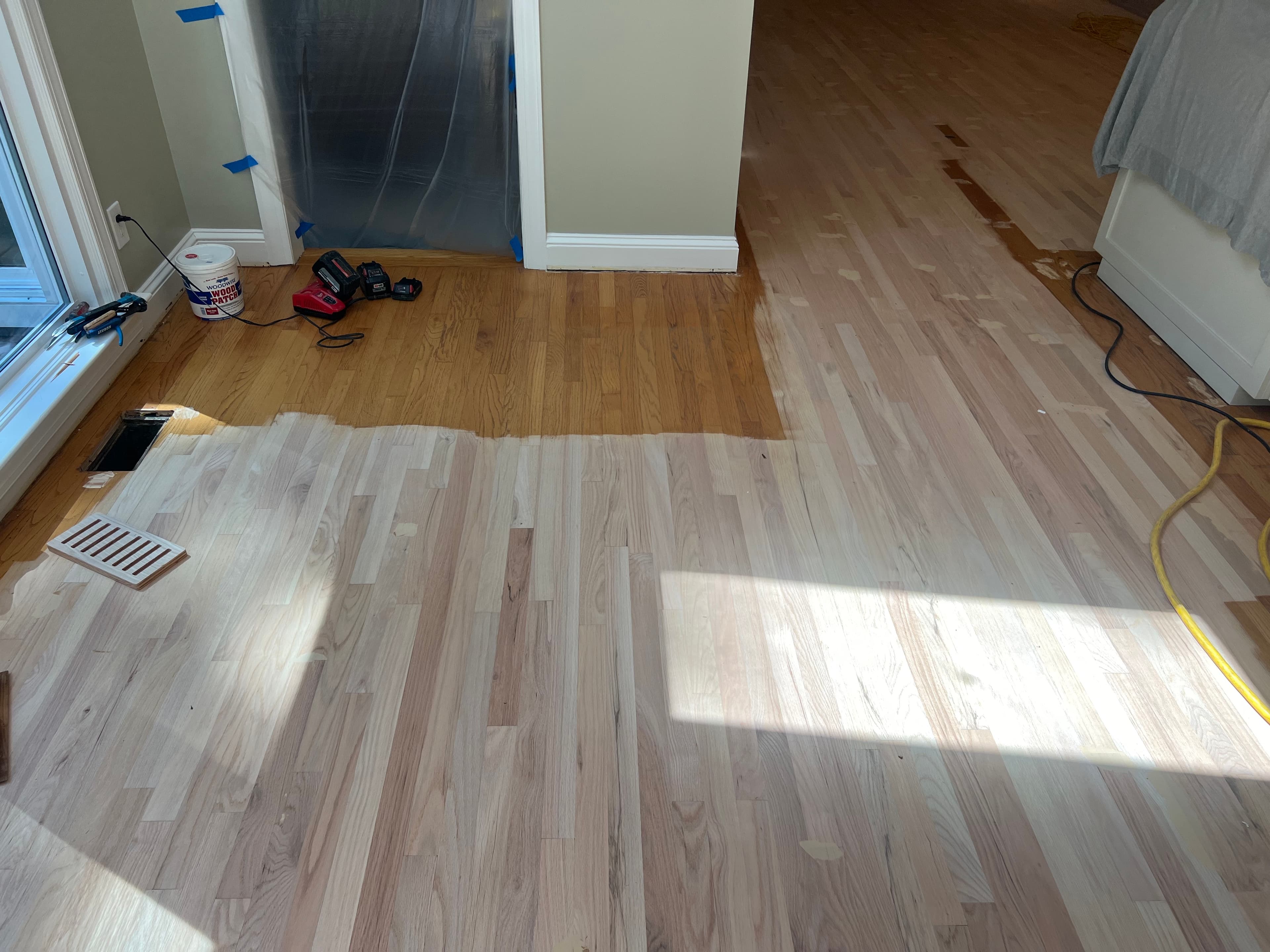 Red oak floors mid-sanding in Lochmere Cary NC, showing contrast between sanded bare wood and remaining old finish