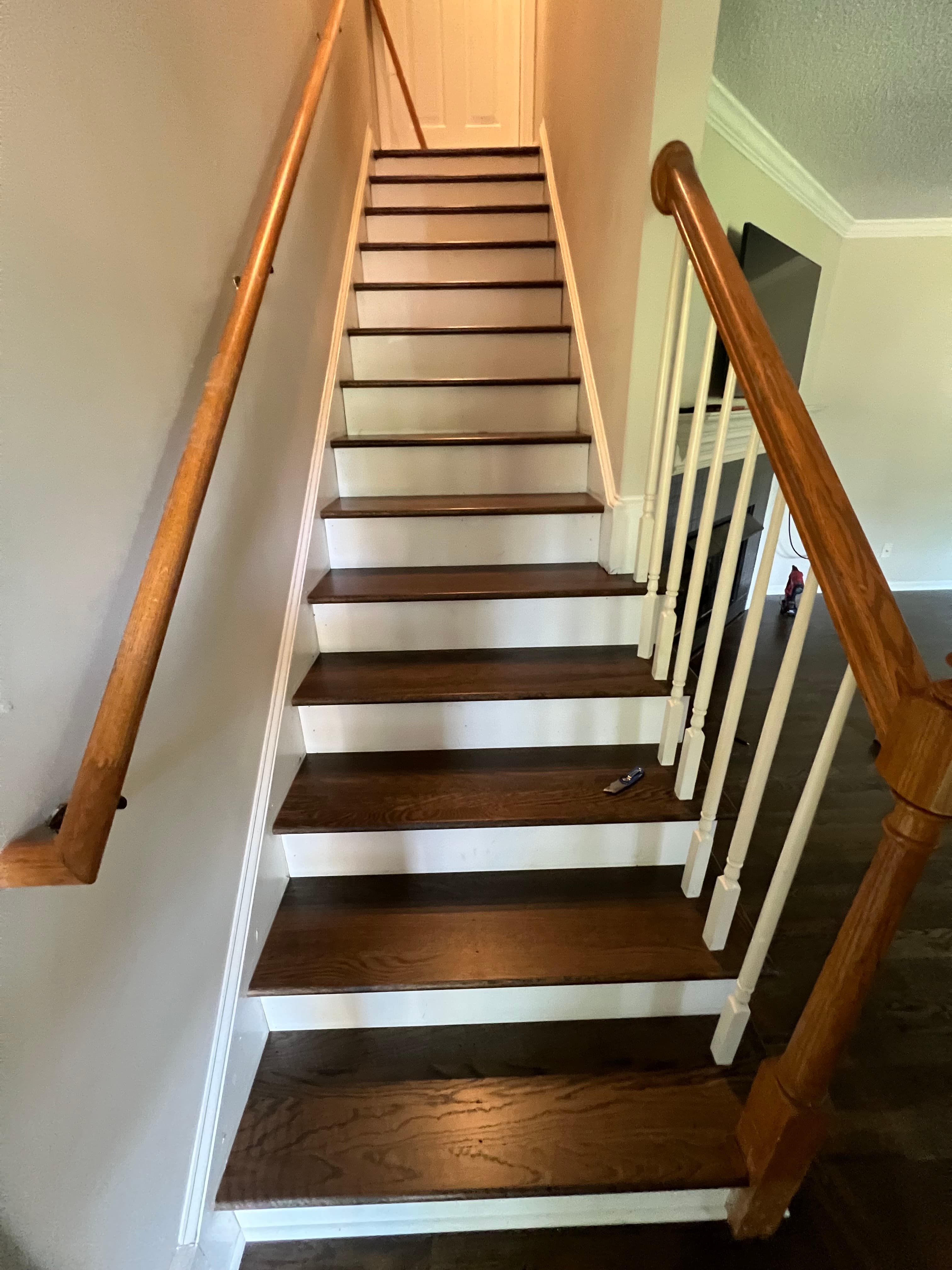 Finished white oak stair treads with custom stain blend and Bona Traffic HD in North Fort Clayton NC, looking down full staircase with matching hardwood floor at base