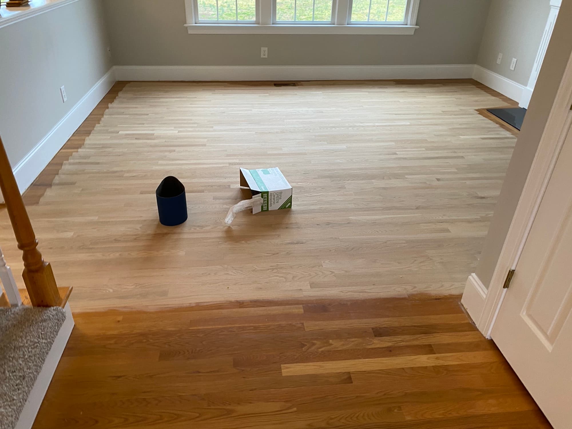 Big machine sanding white oak floor in Wake Forest NC showing dramatic contrast between old finish and bare wood
